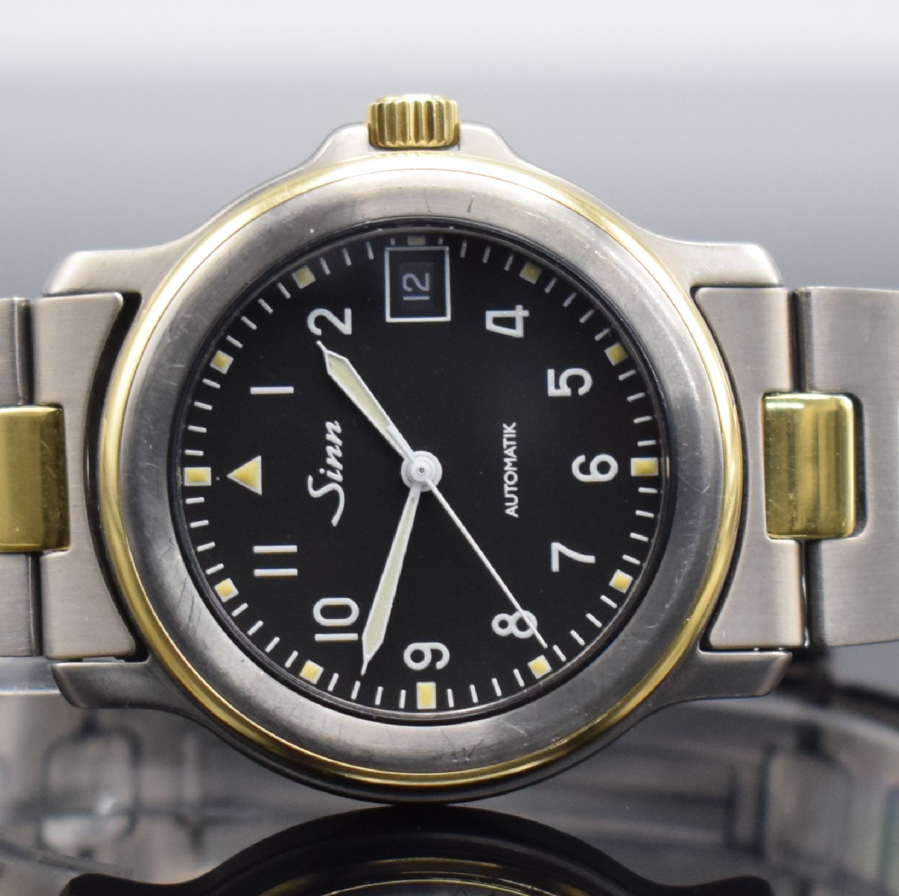Detail a: SINN Chronometer Herrenarmbanduhr, Schweiz/ Deutschland um 1995, Automatik, Titan/Gold komb., Gliederband m. Faltschl., schwarzes Zifferbl. m. arab. ...