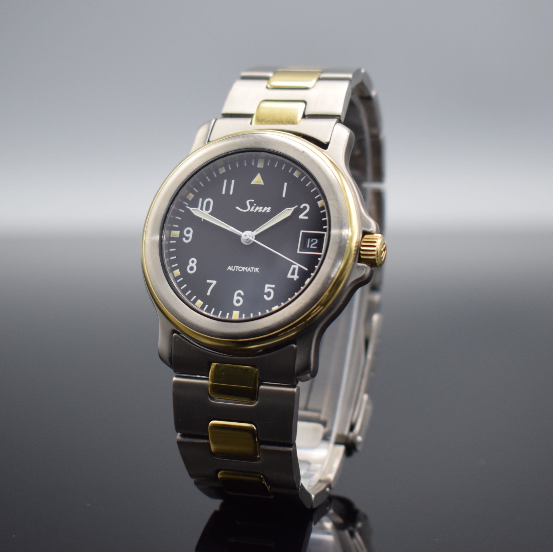 Detail b: SINN Chronometer Herrenarmbanduhr, Schweiz/ Deutschland um 1995, Automatik, Titan/Gold komb., Gliederband m. Faltschl., schwarzes Zifferbl. m. arab. ...