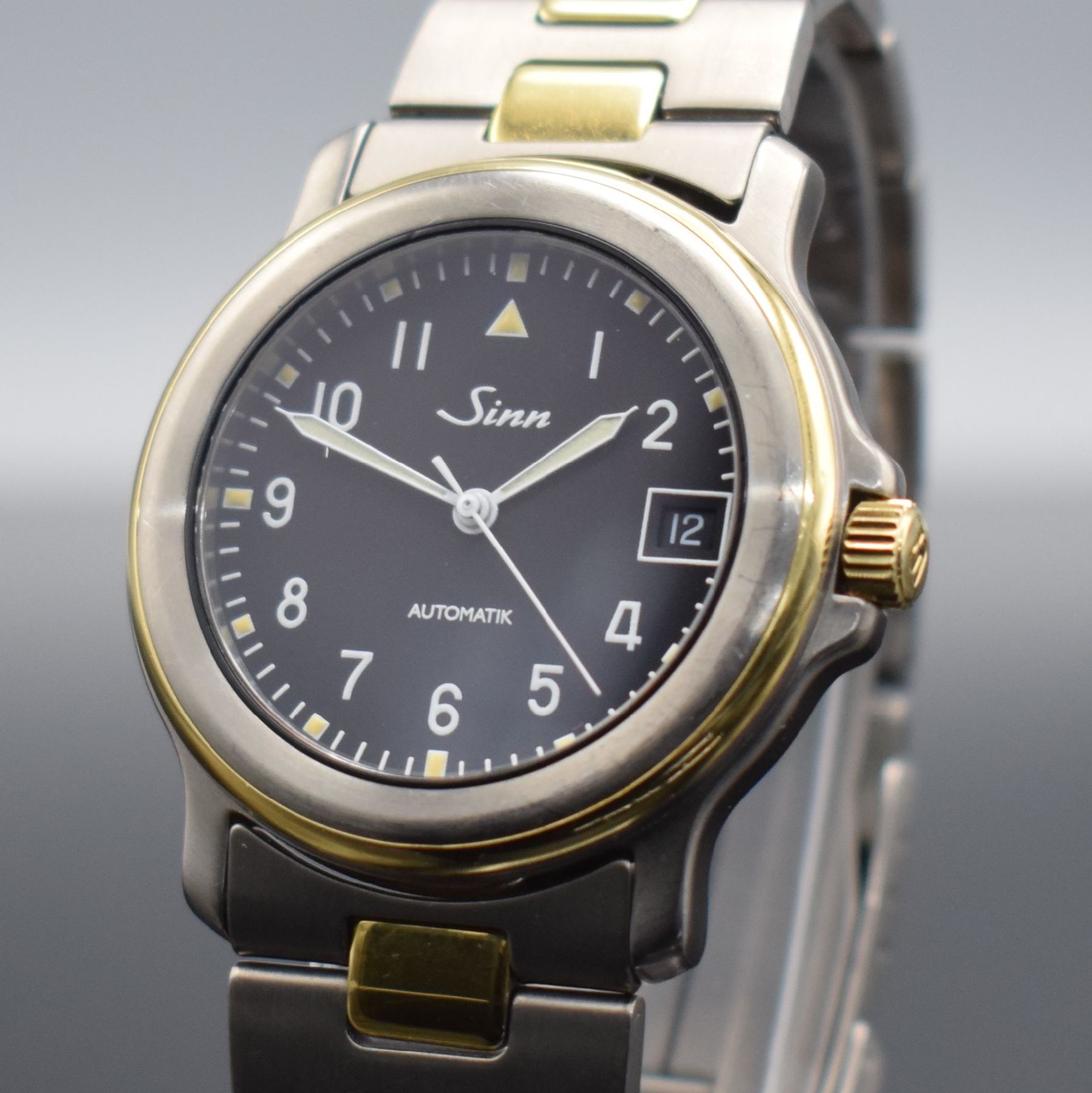 Detail c: SINN Chronometer Herrenarmbanduhr, Schweiz/ Deutschland um 1995, Automatik, Titan/Gold komb., Gliederband m. Faltschl., schwarzes Zifferbl. m. arab. ...