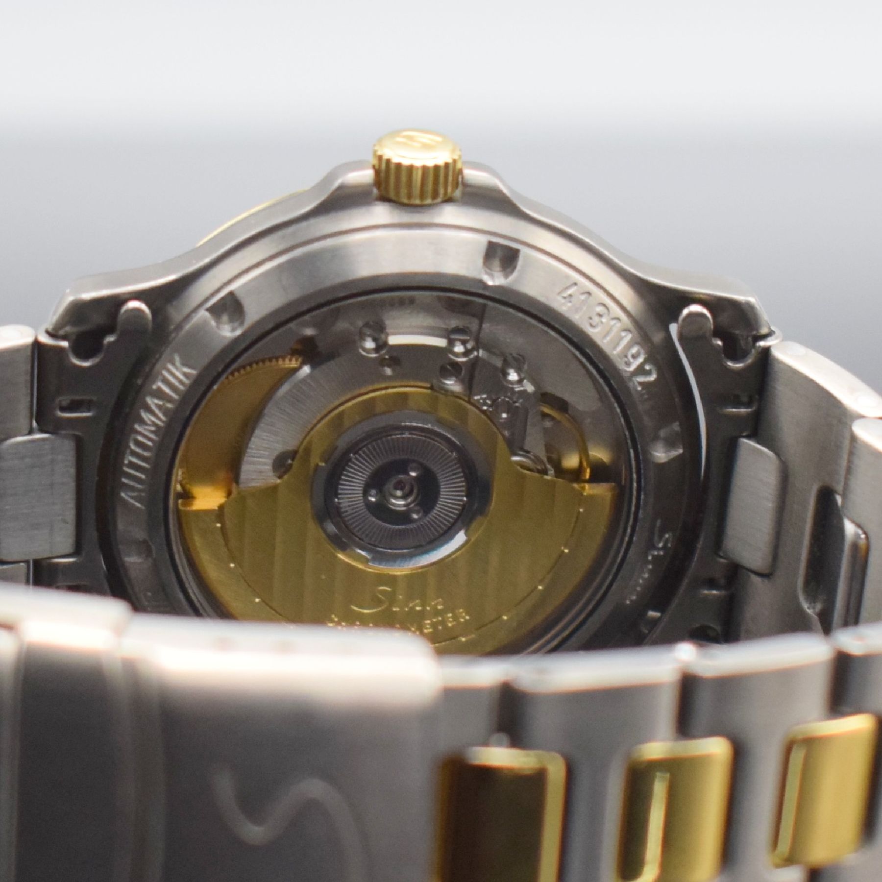 Detail e: SINN Chronometer Herrenarmbanduhr, Schweiz/ Deutschland um 1995, Automatik, Titan/Gold komb., Gliederband m. Faltschl., schwarzes Zifferbl. m. arab. ...