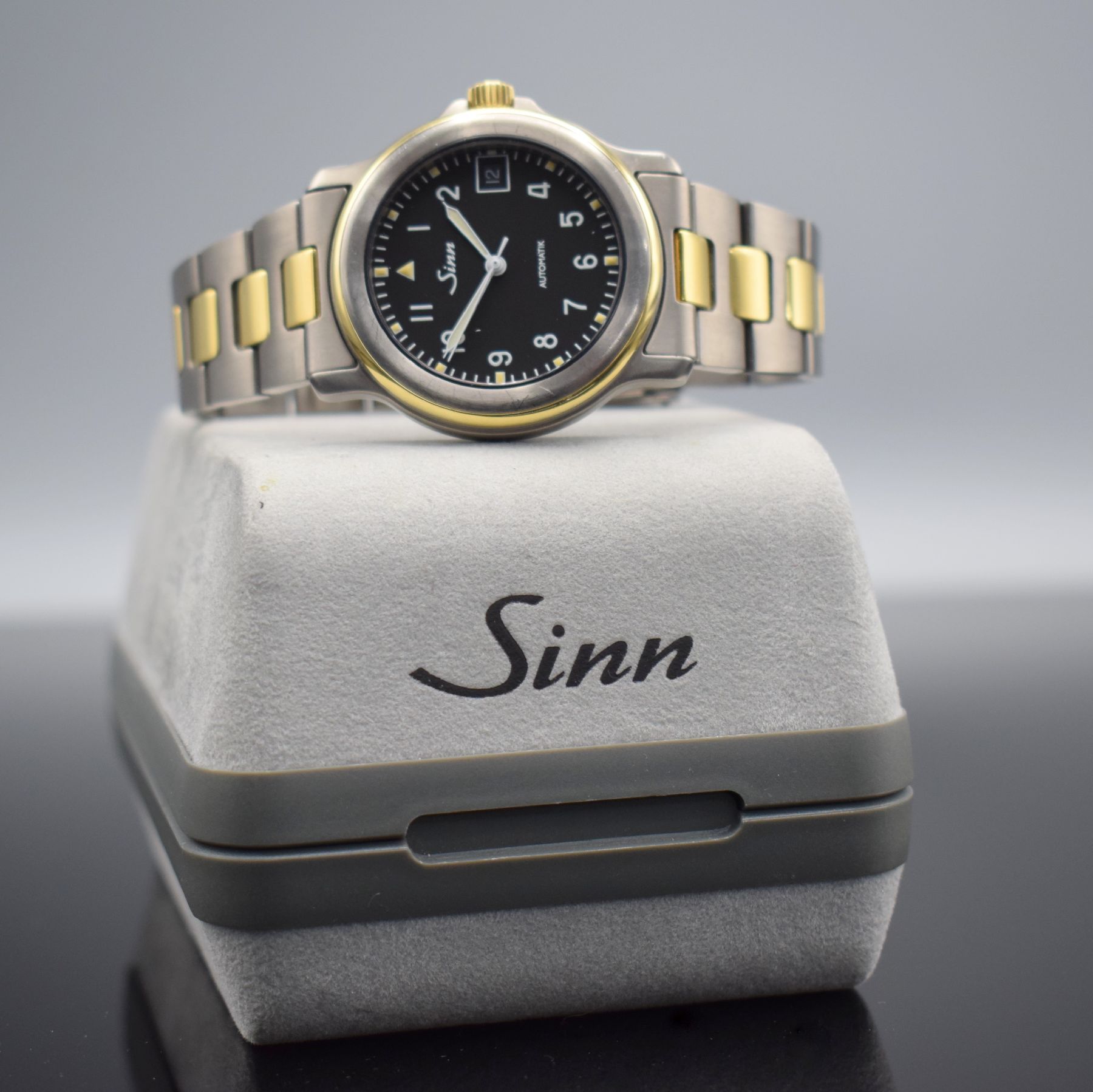 Detail h: SINN Chronometer Herrenarmbanduhr, Schweiz/ Deutschland um 1995, Automatik, Titan/Gold komb., Gliederband m. Faltschl., schwarzes Zifferbl. m. arab. ...