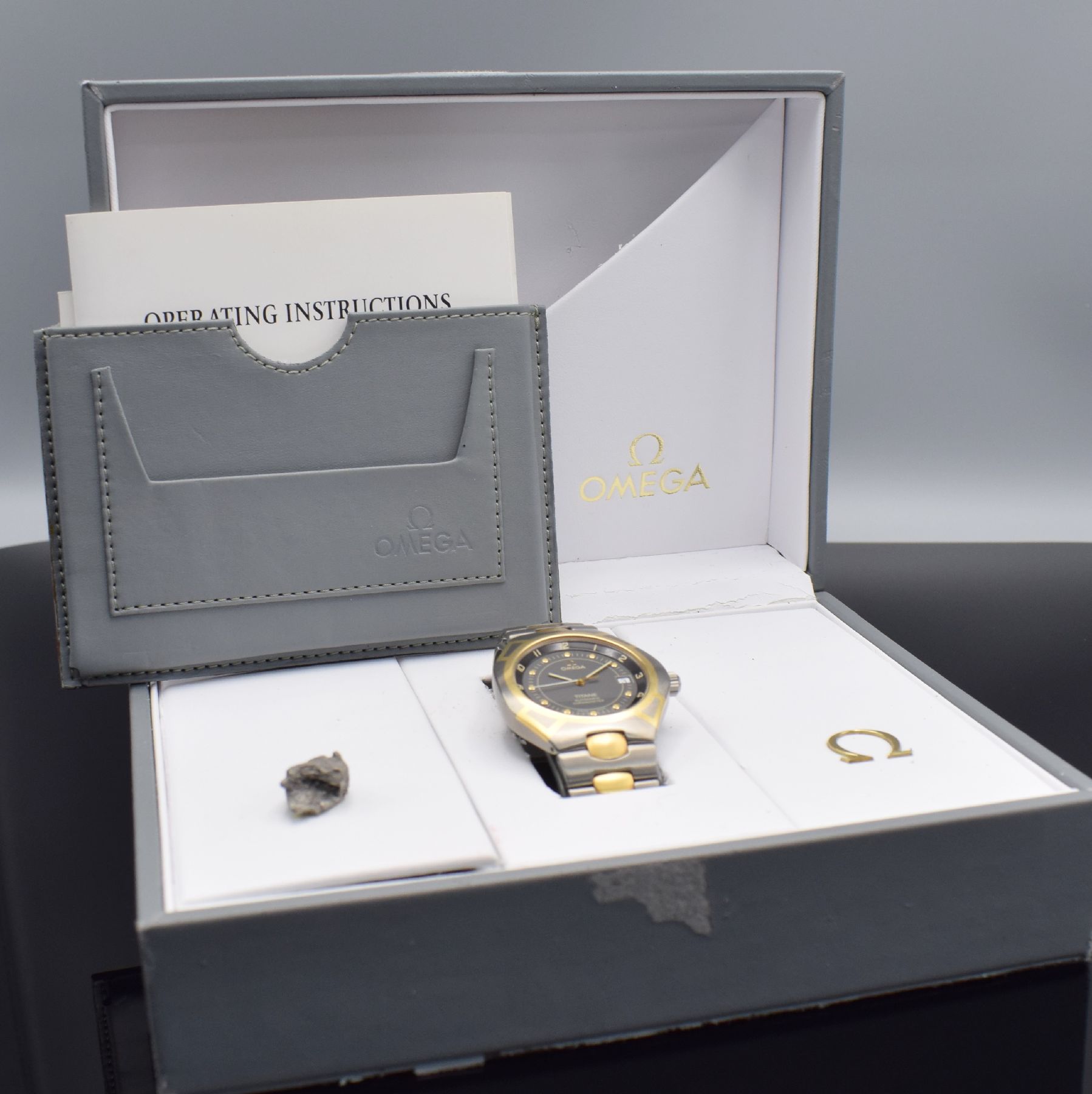 Detail h: OMEGA Seamaster Titane Chronometer Herrenarmbanduhr Referenz 3680885, Schweiz um 1995, Automatik, goldintarsiertes Titangeh. inkl. Gliederband m. ...