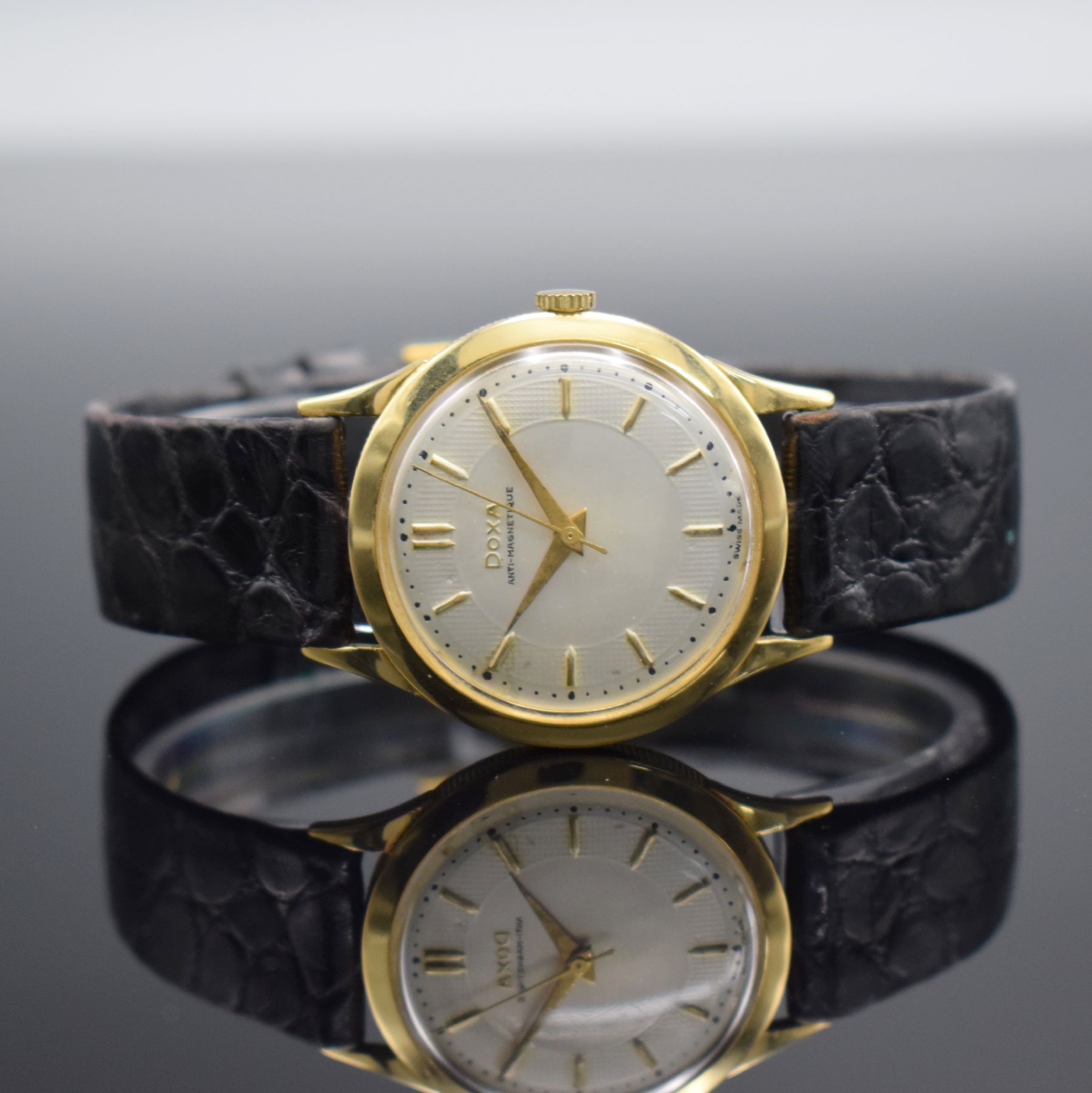DOXA Herrenarmbanduhr in GG 750/000, Schweiz um 1960, Handaufzug, 3-teil. Geh. m. Münzranddell., Boden & Glasrand aufgedr., silb. Zifferbl. m. gold. ...
