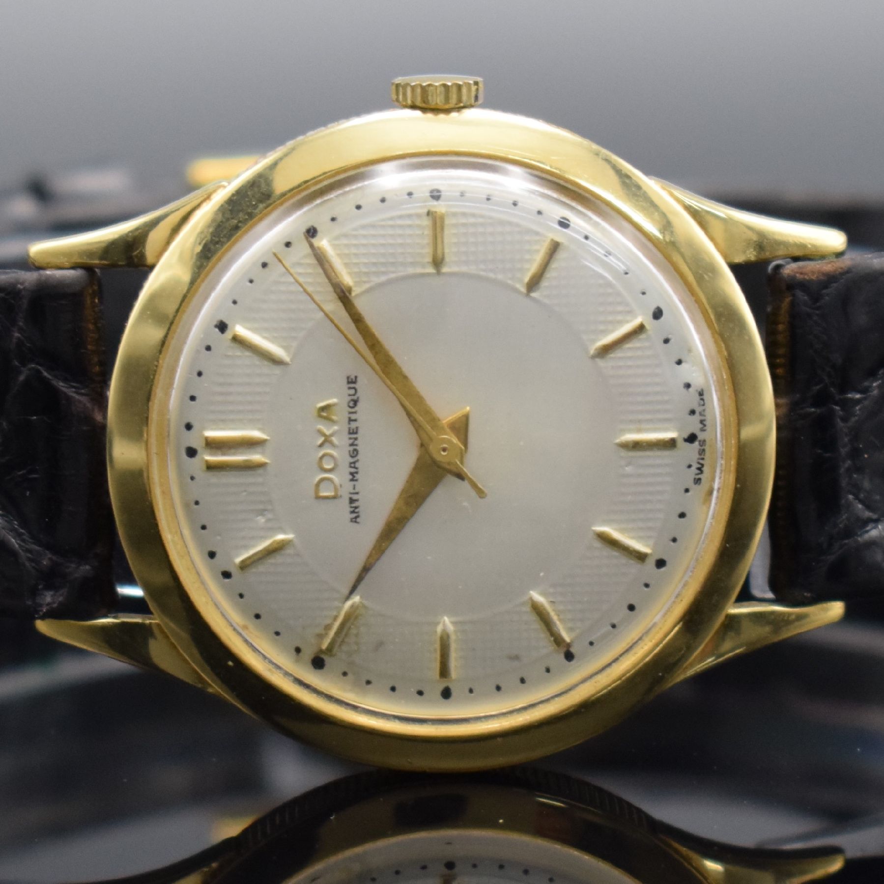 Detail a: DOXA Herrenarmbanduhr in GG 750/000, Schweiz um 1960, Handaufzug, 3-teil. Geh. m. Münzranddell., Boden & Glasrand aufgedr., silb. Zifferbl. m. gold. ...