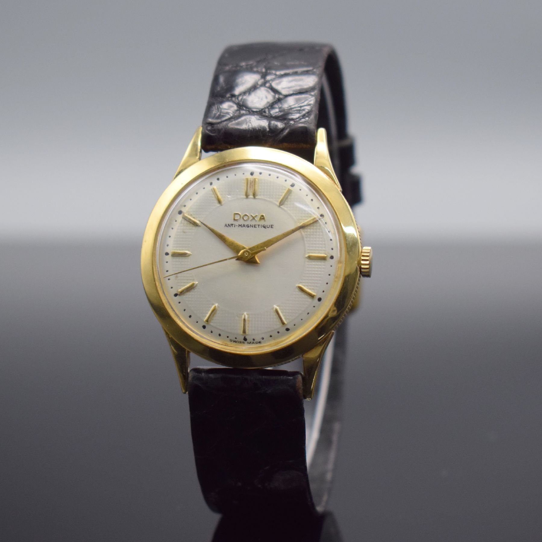 Detail b: DOXA Herrenarmbanduhr in GG 750/000, Schweiz um 1960, Handaufzug, 3-teil. Geh. m. Münzranddell., Boden & Glasrand aufgedr., silb. Zifferbl. m. gold. ...