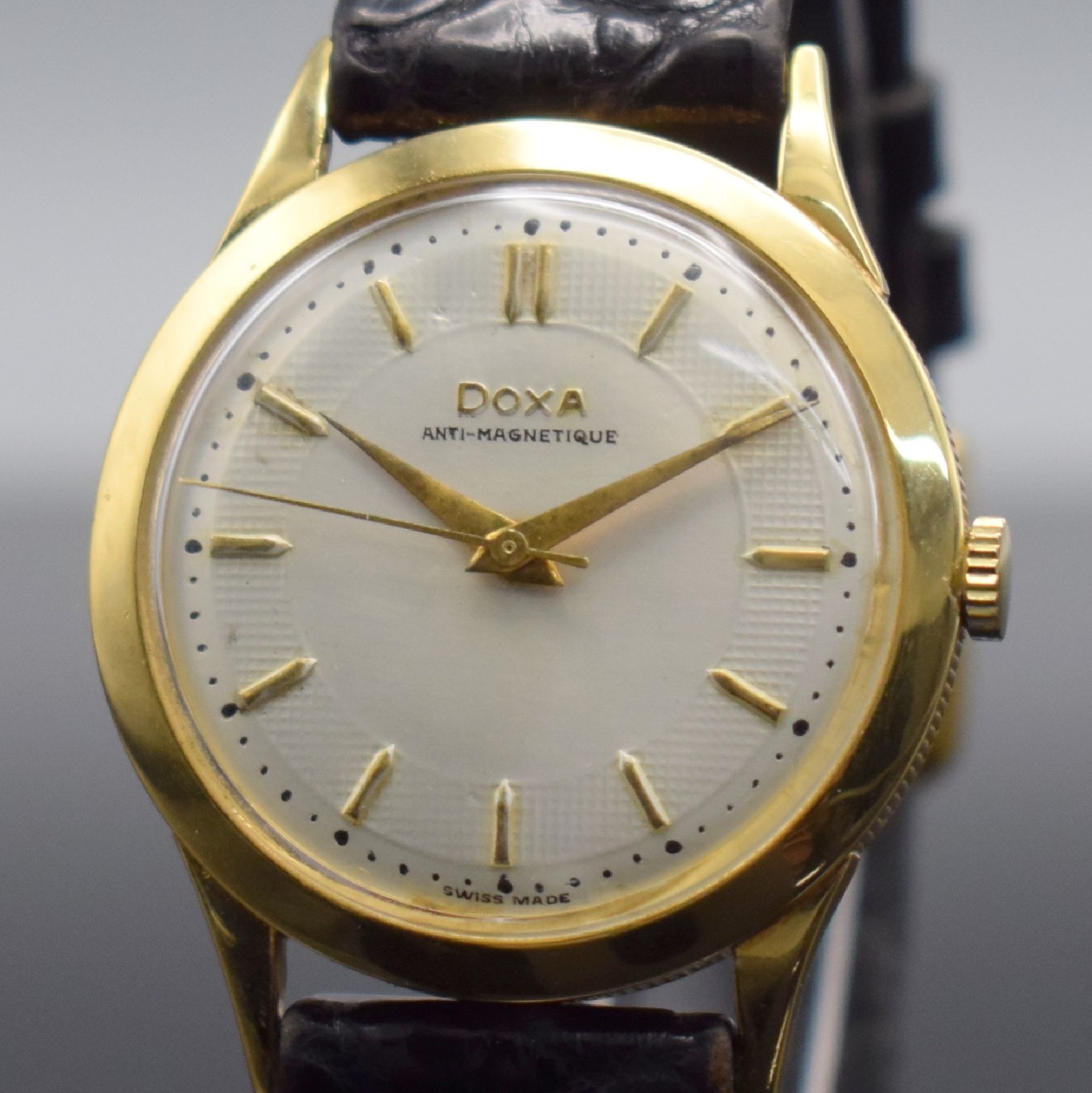 Detail c: DOXA Herrenarmbanduhr in GG 750/000, Schweiz um 1960, Handaufzug, 3-teil. Geh. m. Münzranddell., Boden & Glasrand aufgedr., silb. Zifferbl. m. gold. ...