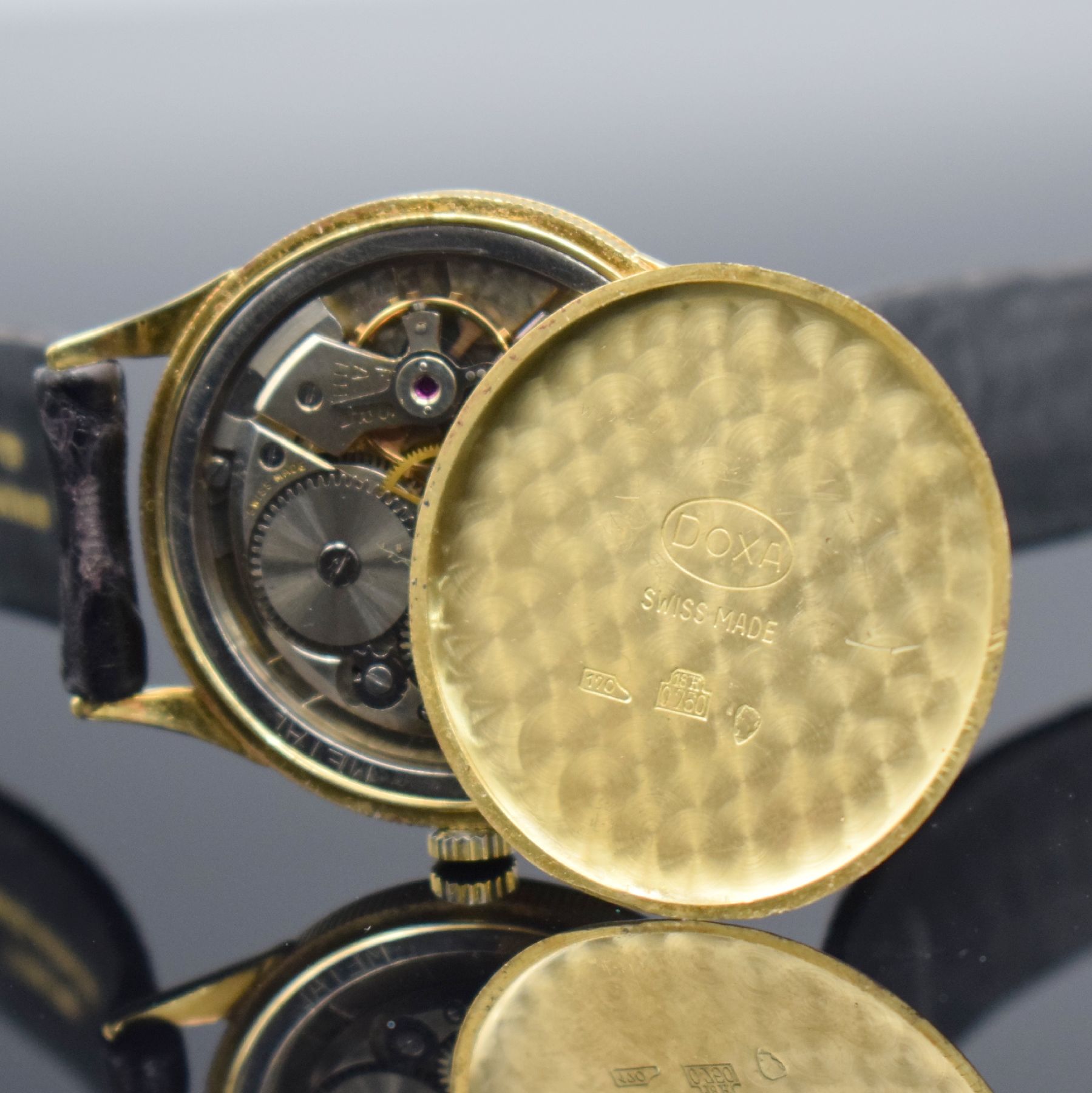 Detail h: DOXA Herrenarmbanduhr in GG 750/000, Schweiz um 1960, Handaufzug, 3-teil. Geh. m. Münzranddell., Boden & Glasrand aufgedr., silb. Zifferbl. m. gold. ...