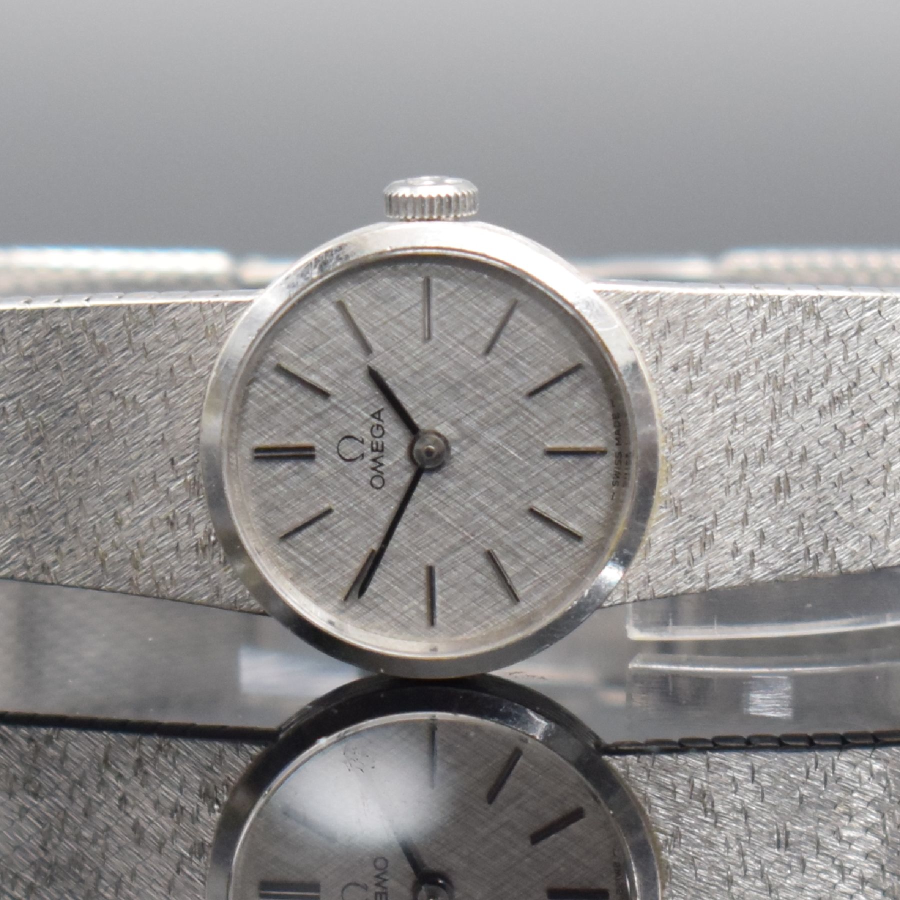 Detail a: OMEGA Damenarmbanduhr in WG 585/000, Schweiz um 1973, Handaufzug, Boden aufgedr., orig. Milanaiseband in WG 585/000, silb. Strukturzifferbl. m. ...