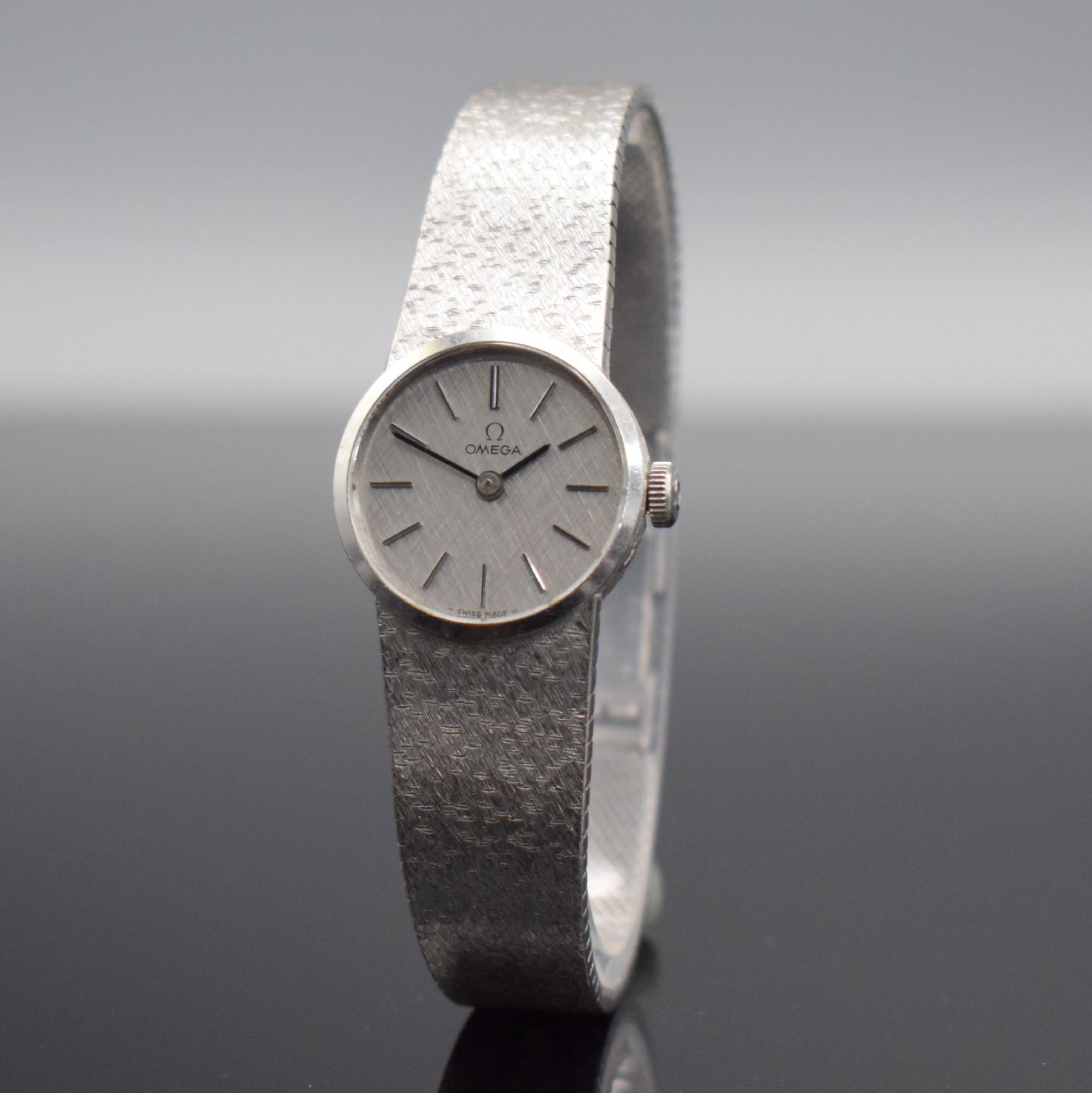 Detail b: OMEGA Damenarmbanduhr in WG 585/000, Schweiz um 1973, Handaufzug, Boden aufgedr., orig. Milanaiseband in WG 585/000, silb. Strukturzifferbl. m. ...