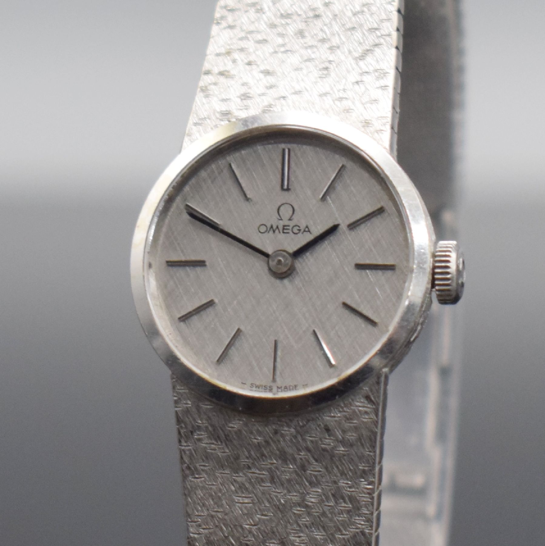 Detail c: OMEGA Damenarmbanduhr in WG 585/000, Schweiz um 1973, Handaufzug, Boden aufgedr., orig. Milanaiseband in WG 585/000, silb. Strukturzifferbl. m. ...