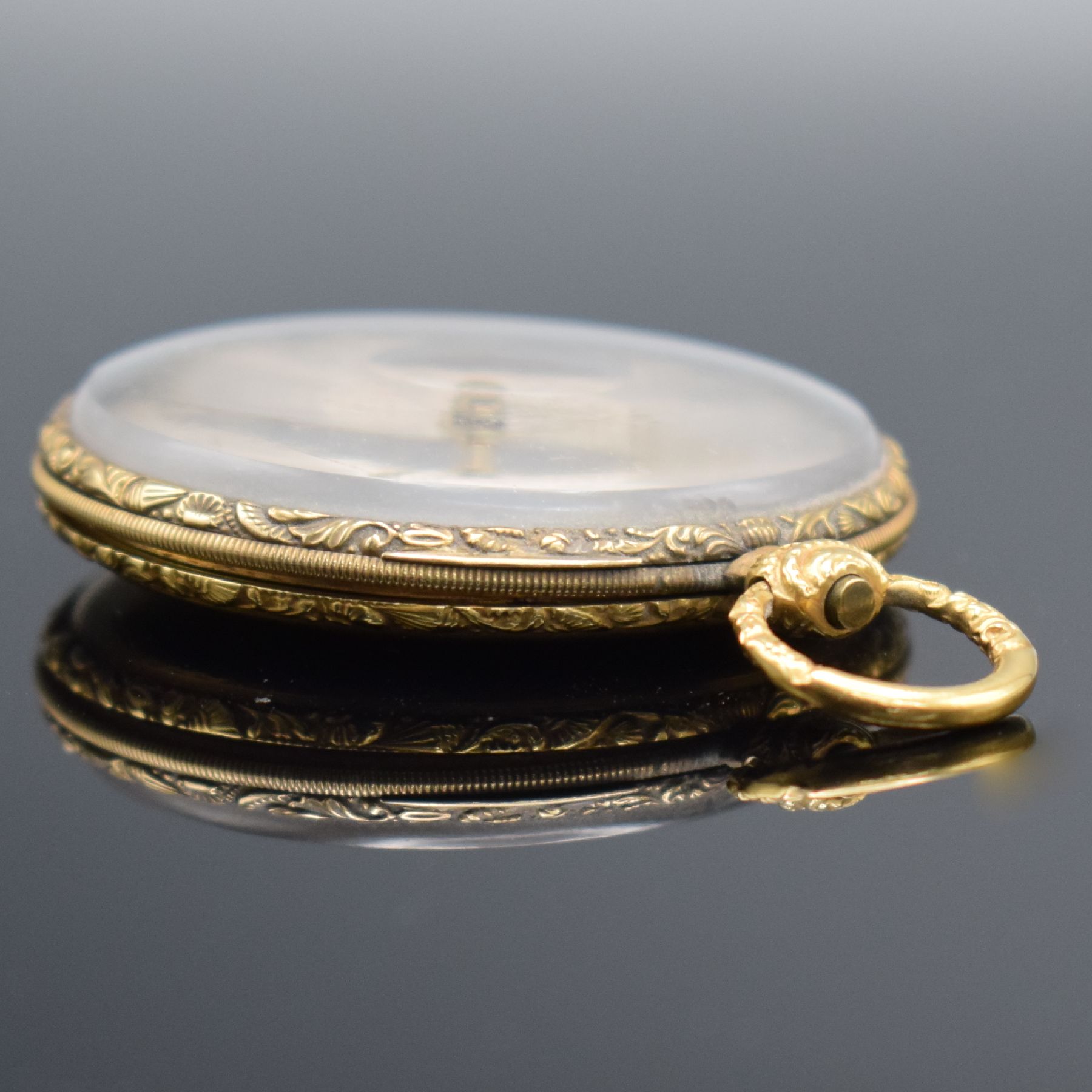 Detail c: Offene Taschenuhr in GG 750/000, Schweiz um 1850, Metallcuvette, floral grav. Ränder, guill. Rückseite, silb. Zifferbl. m. röm. Zahlen z. T. ...