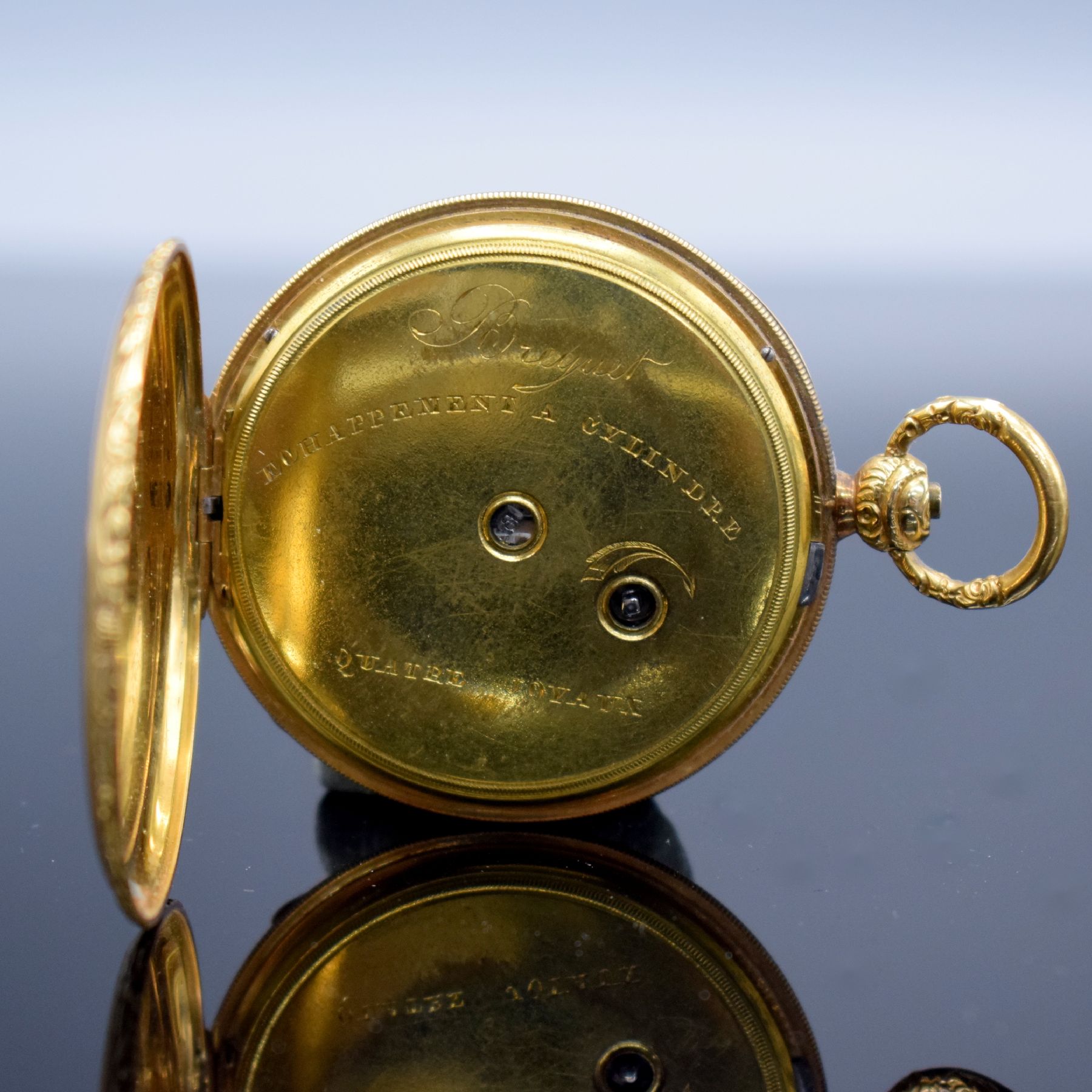 Detail d: Offene Taschenuhr in GG 750/000, Schweiz um 1850, Metallcuvette, floral grav. Ränder, guill. Rückseite, silb. Zifferbl. m. röm. Zahlen z. T. ...