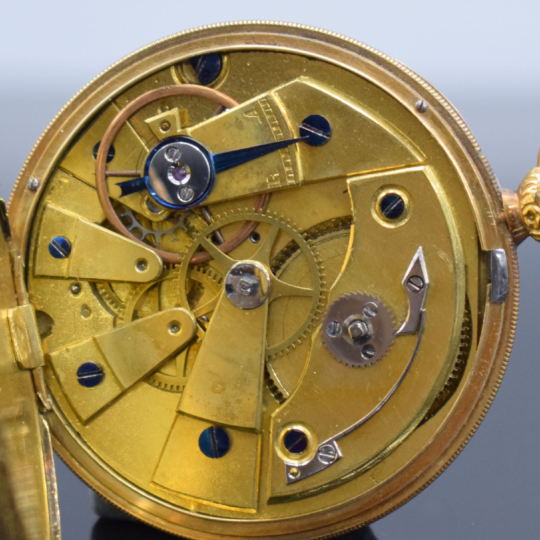 Detail f: Offene Taschenuhr in GG 750/000, Schweiz um 1850, Metallcuvette, floral grav. Ränder, guill. Rückseite, silb. Zifferbl. m. röm. Zahlen z. T. ...