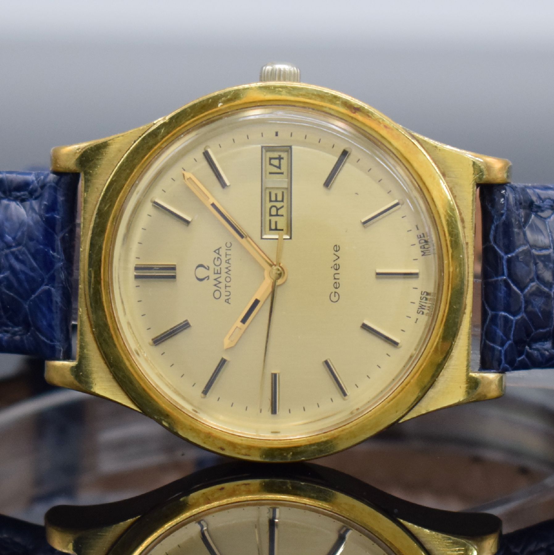 Detail a: OMEGA Geneve Herrenarmbanduhr mit Tag & Datum, Schweiz um 1972, Automatik, Ref. 166 0169, verg. Geh., Stahlboden geschr., gold. Zifferbl. m. aufges. ...