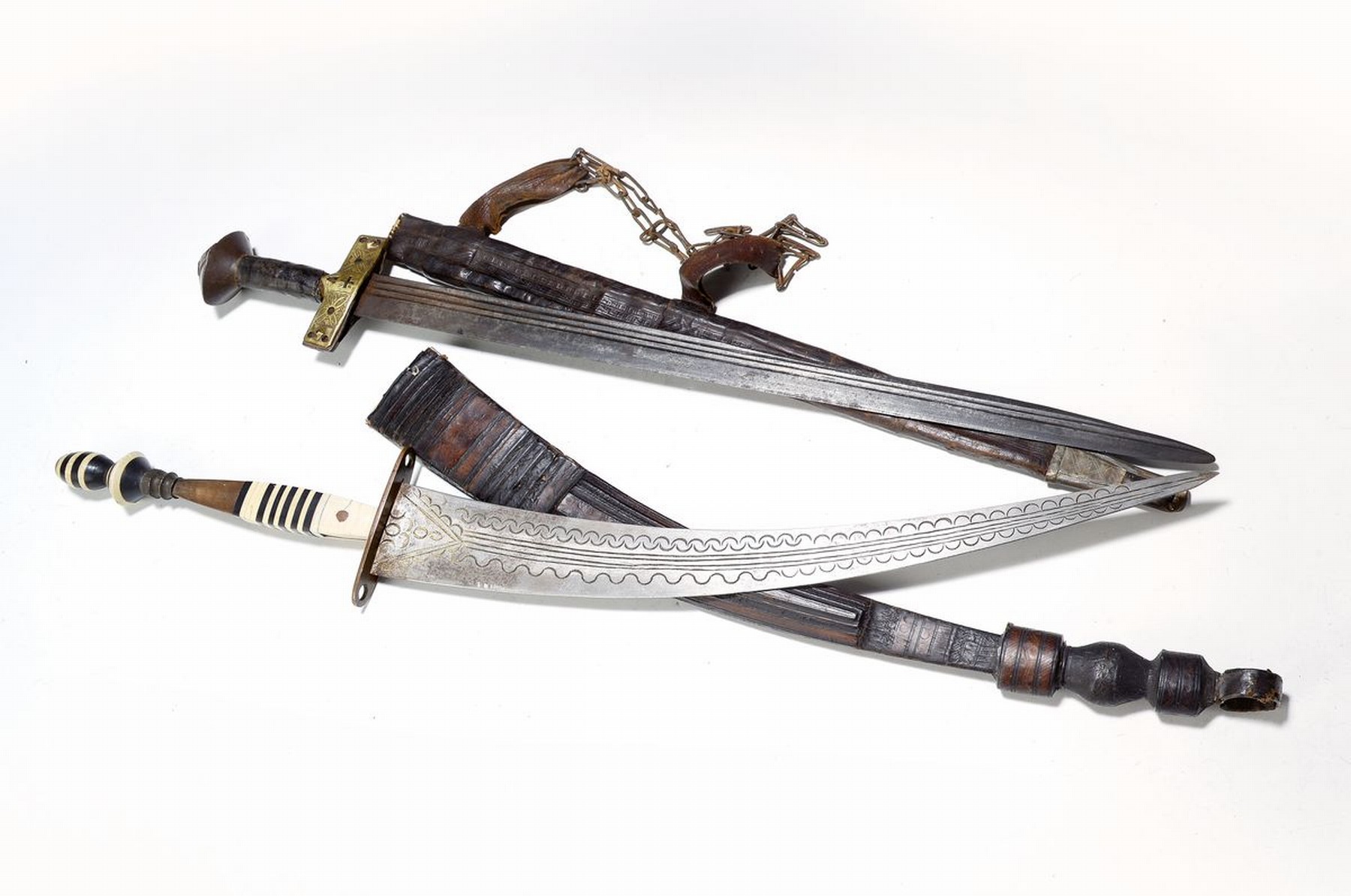Krummsäbel und Kurzschwert, Sudan/Tuareg, um 1900, Stahlklingen, Messingbeschlag, Lederscheiden, geprägt, Alterssp., L. ca. 77cm