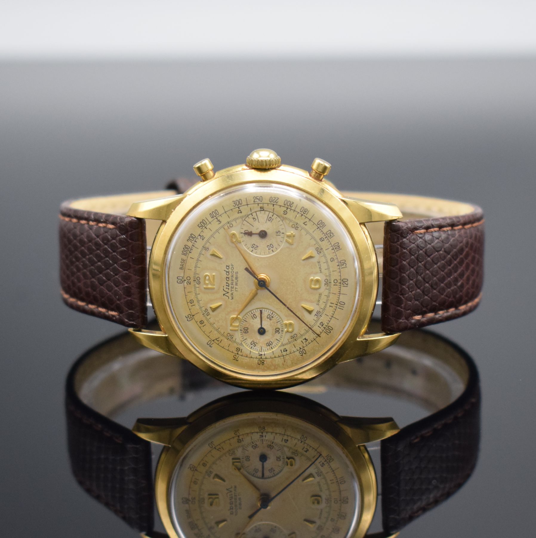 NIVADA Schaltradchronograph in GG 750/000, Schweiz um 1950, Handaufzug, 2-tlg. Geh., Boden aufgedr., silb. Zifferbl. pat., gold. Ind. & Zahlen, orig. ...
