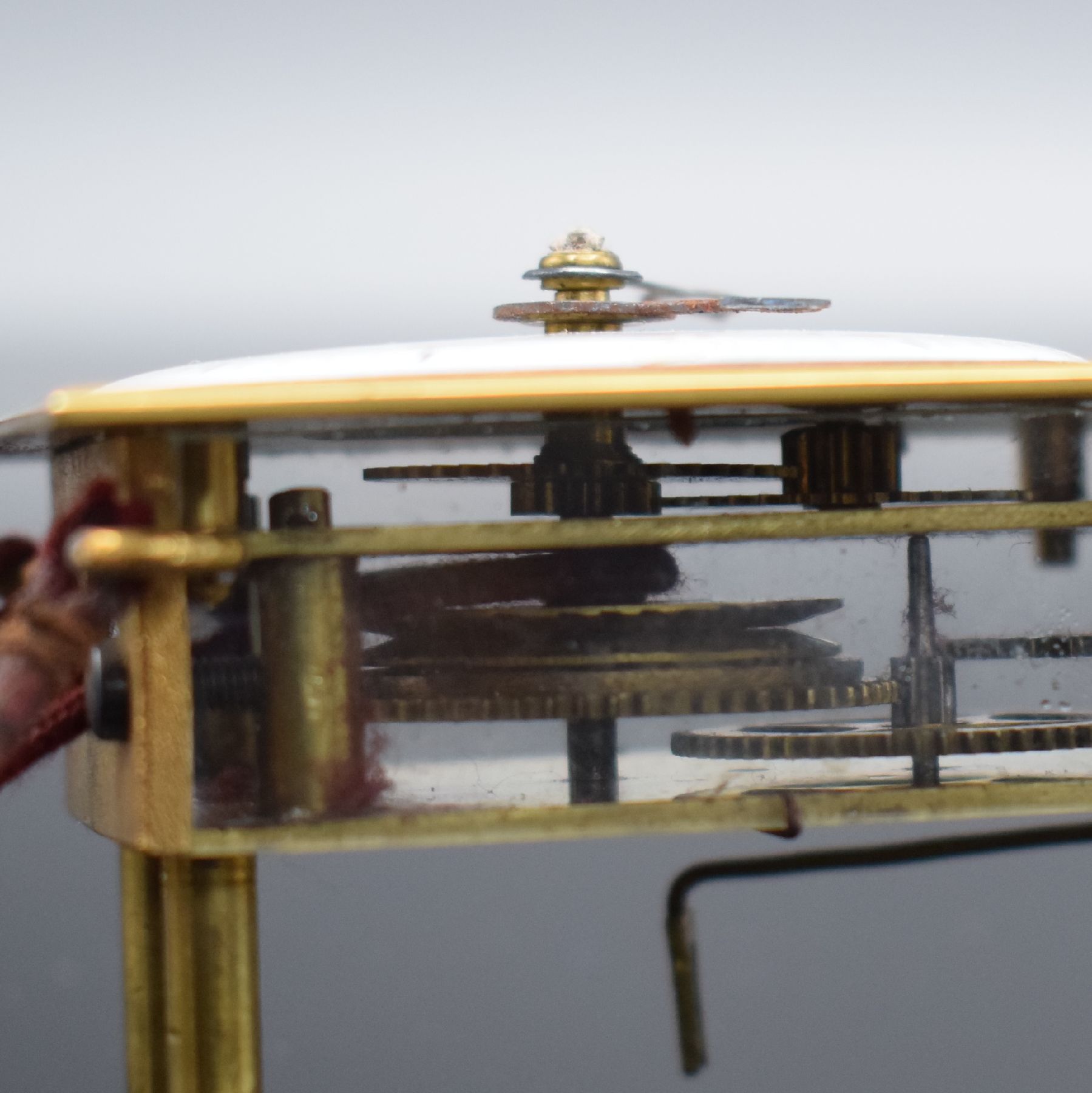 Detail d: Seltene Miniatur-Wanduhr mit Huygensschem Aufzug, um 1880, justierbares Holzbrett, darauf montierte Messingplatte m. Pendel- & Werkaufhängung, ...
