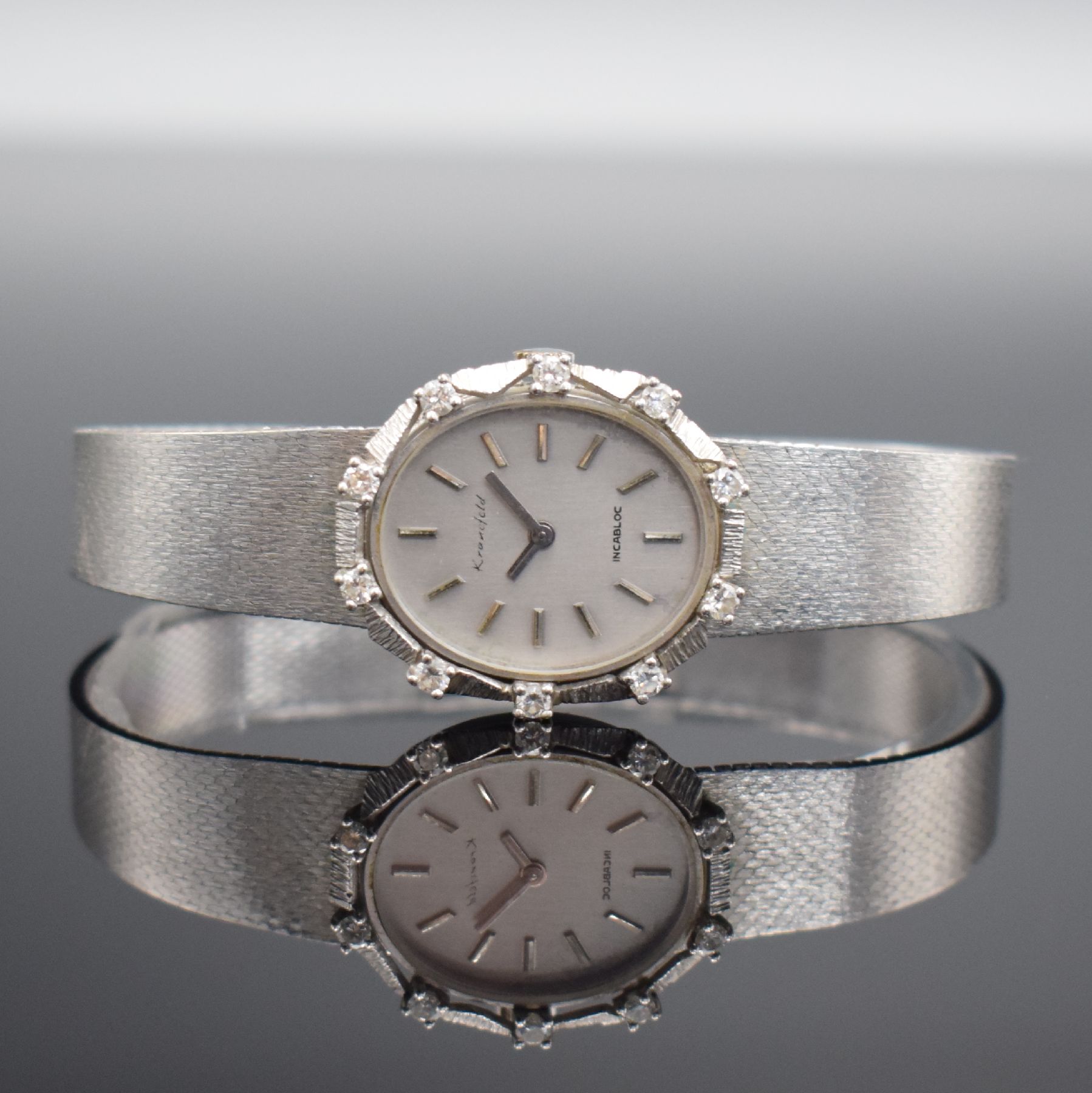 KRANEFELD Damenarmbanduhr mit Diamantbesatz in WG 585/000, Schweiz um 1970, Handaufzug, Geh. an WG 585/000 Band, Boden aufgedr., silb. Zifferbl. m. ...