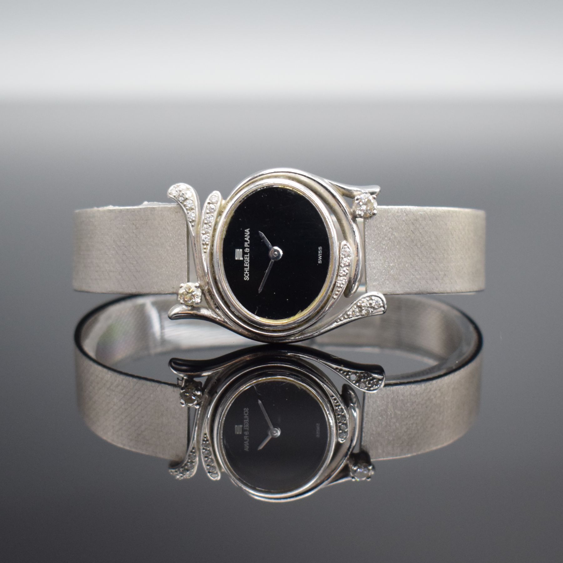 SCHLEGEL & PLANA Damenarmbanduhr mit Diamanten in WG 750/000, Schweiz um 1970, Handaufzug, Boden aufgedr., Goldband in WG 750/000, schwarzes ...