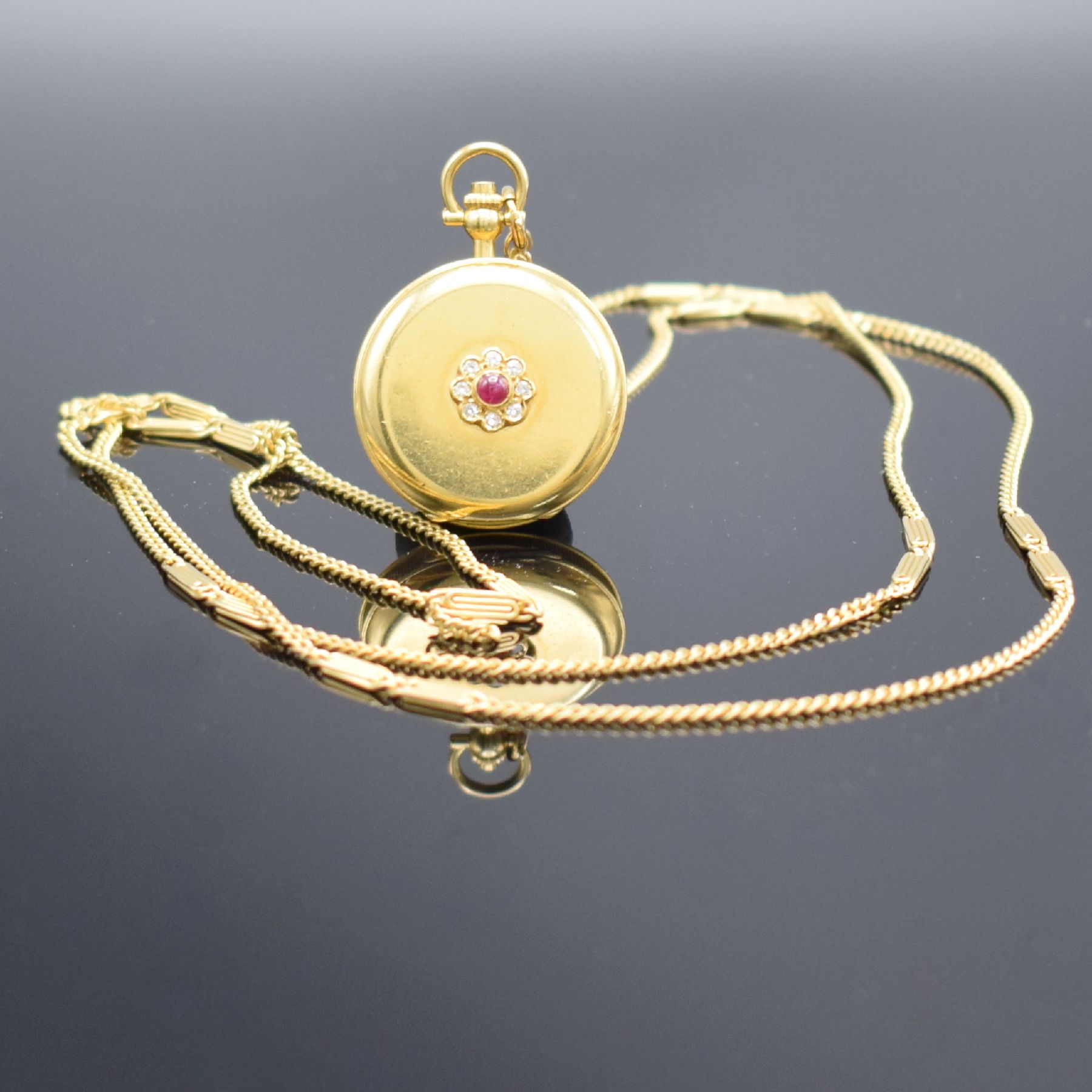 CHOPARD Damentaschenuhr in GG 750/000 mit Kette in GG 585/000, Schweiz um 1985, Handaufzug, Stülpgeh., Sprungdeckel im Zentrum m. Rubincabochon & ...