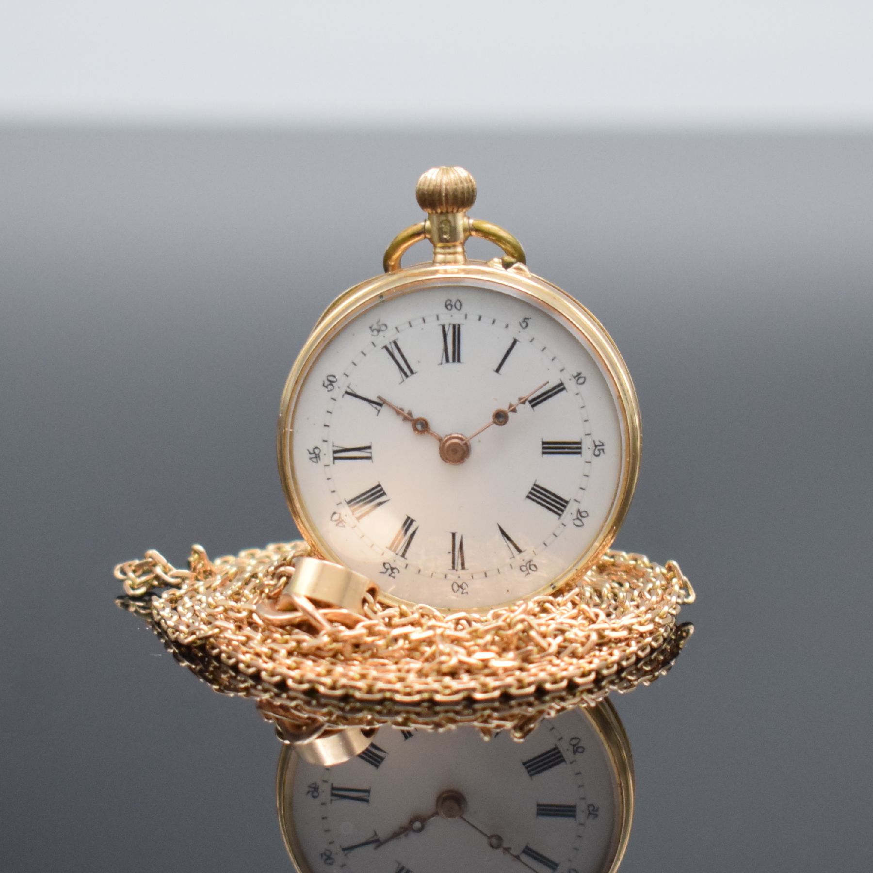 Offene Damentaschenuhr in RG 585/000 mit Kettein RG 585/000, Schweiz um 1890, Kette später, Metallcuvette, floral grav. Rückseite, Emailzifferbl. ...