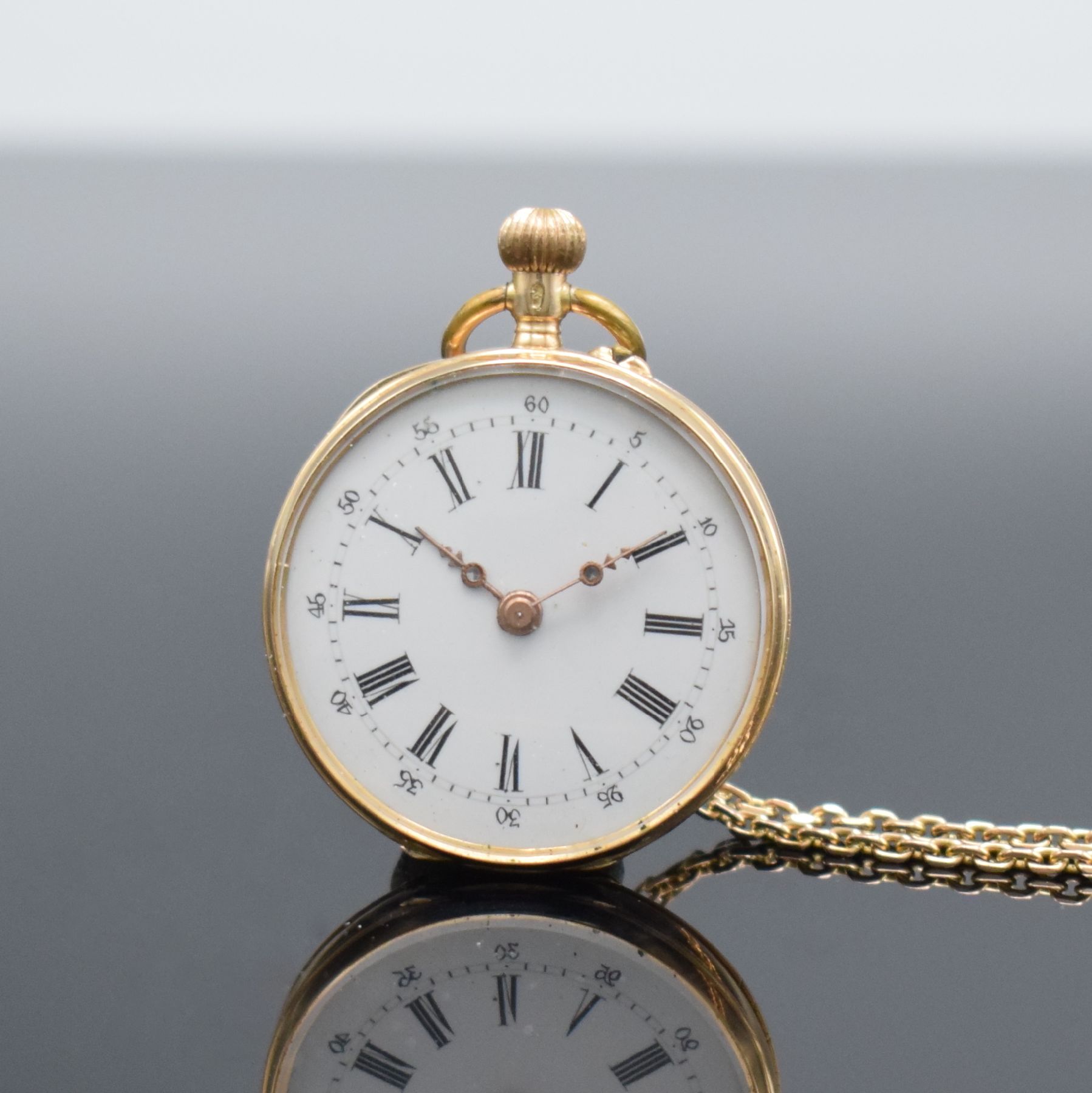 Detail a: Offene Damentaschenuhr in RG 585/000 mit Kettein RG 585/000, Schweiz um 1890, Kette später, Metallcuvette, floral grav. Rückseite, Emailzifferbl. ...