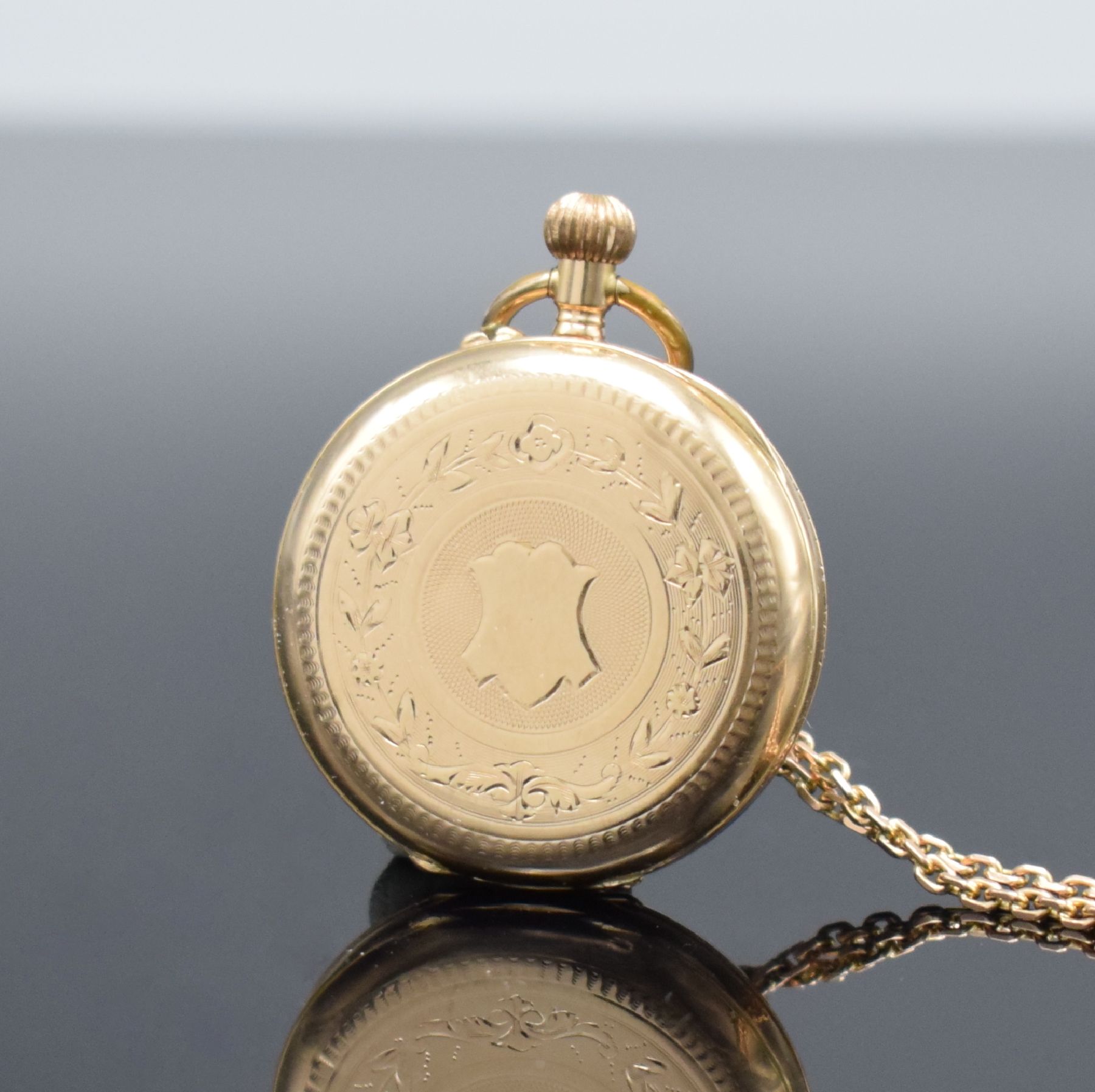 Detail b: Offene Damentaschenuhr in RG 585/000 mit Kettein RG 585/000, Schweiz um 1890, Kette später, Metallcuvette, floral grav. Rückseite, Emailzifferbl. ...