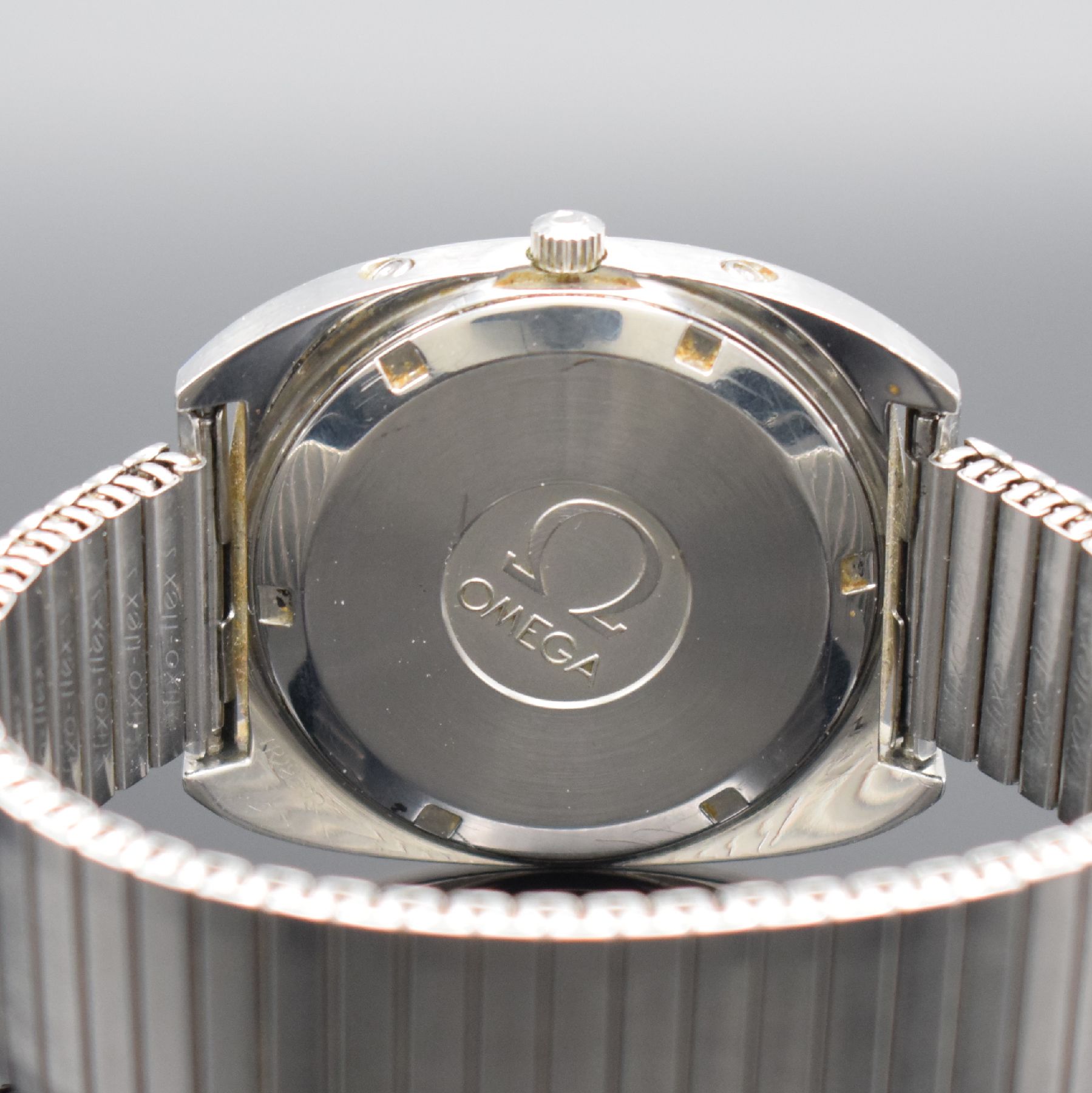Detail e: OMEGA Megaquartz 32 KHz Geneve Herrenarmbanduhr in Stahl Referenz 196.038, Schweiz um 1974, quarz, massives Gehäuse, Boden geschr., silb. Zifferbl. ...