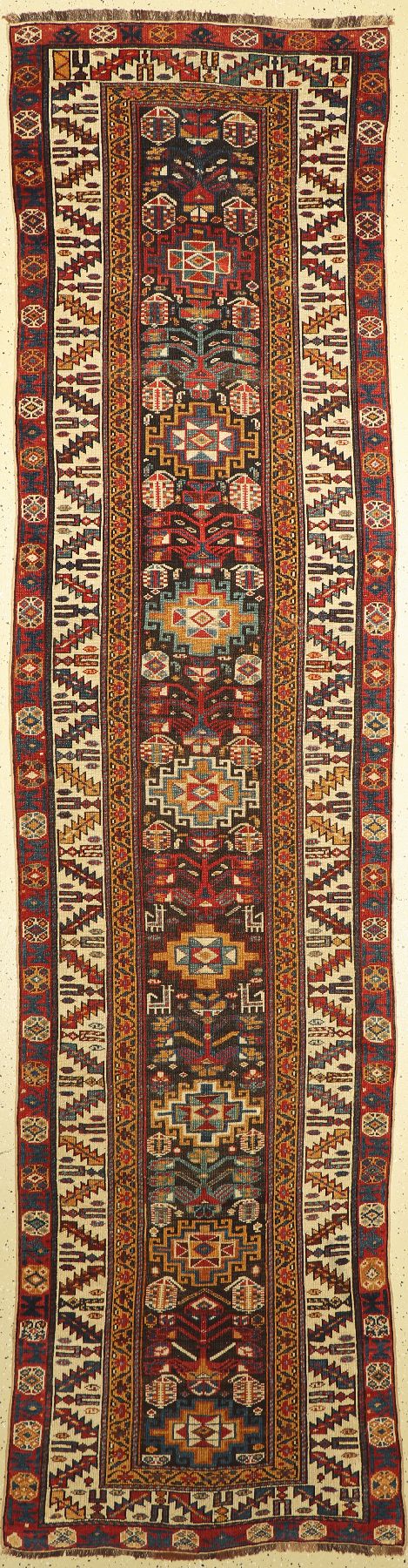 Kazak antik, Kaukasus, um 1880/90, Wolle auf Wolle, ca.375 x 98 cm. Das mit Tiermotiven und Botehs belegte Innenfeld wird von einer breiten weissen ...