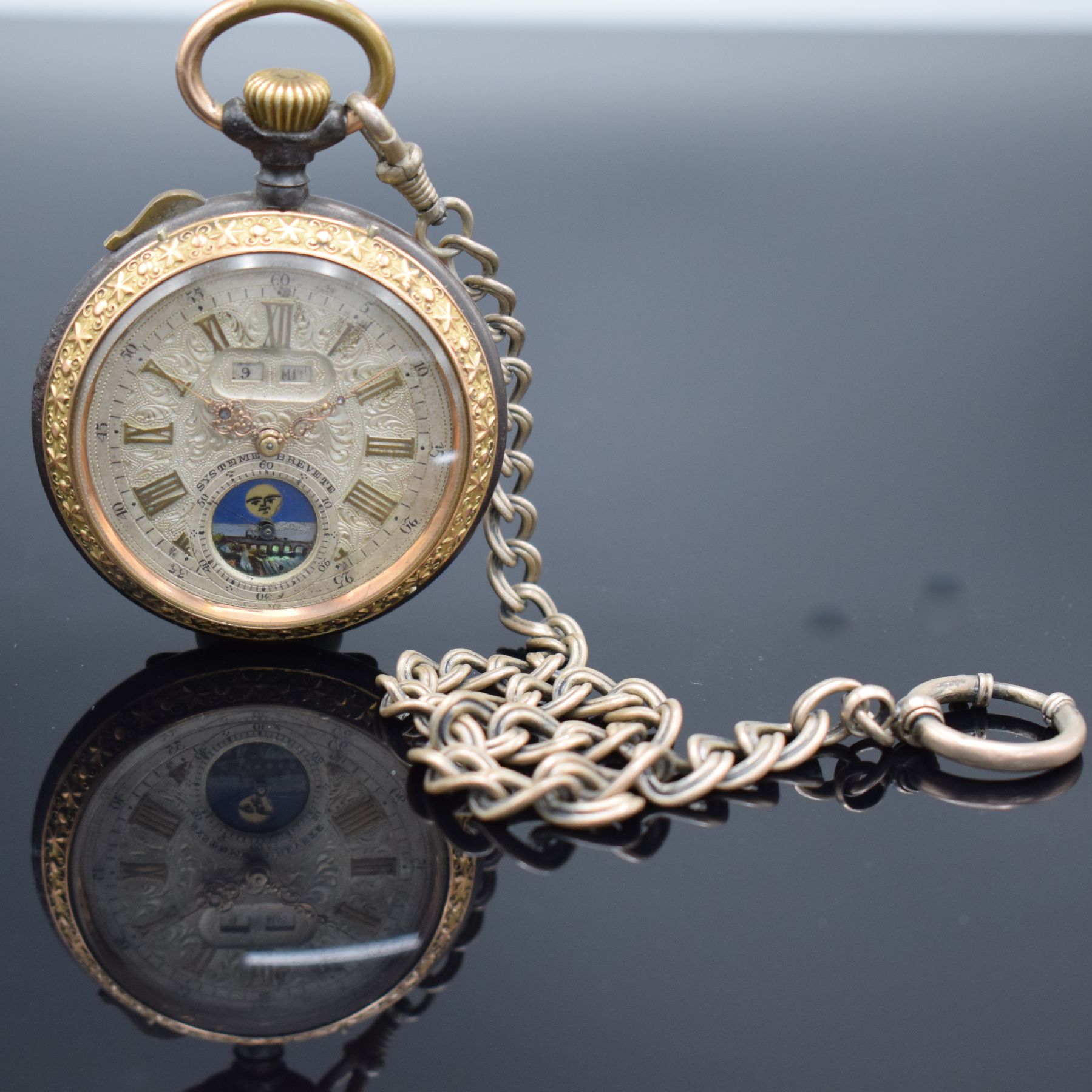 Detail b: Offene Taschenuhr mit Mondphase und Silberkette, Schweiz um 1900, brüniertes Geh. floral dekoriert & verg., Metallzifferbl. m. röm. Zahlen, gold. ...