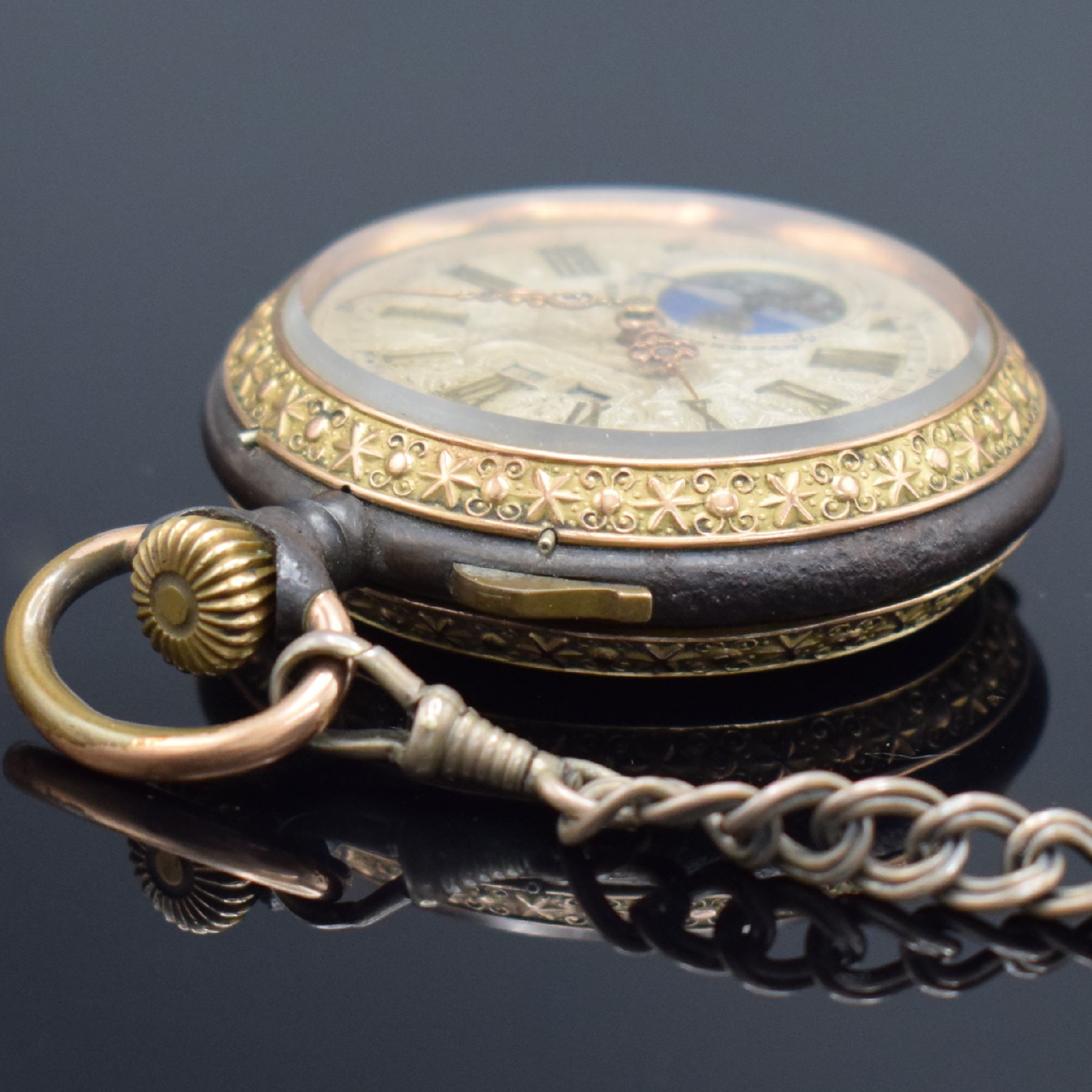 Detail d: Offene Taschenuhr mit Mondphase und Silberkette, Schweiz um 1900, brüniertes Geh. floral dekoriert & verg., Metallzifferbl. m. röm. Zahlen, gold. ...