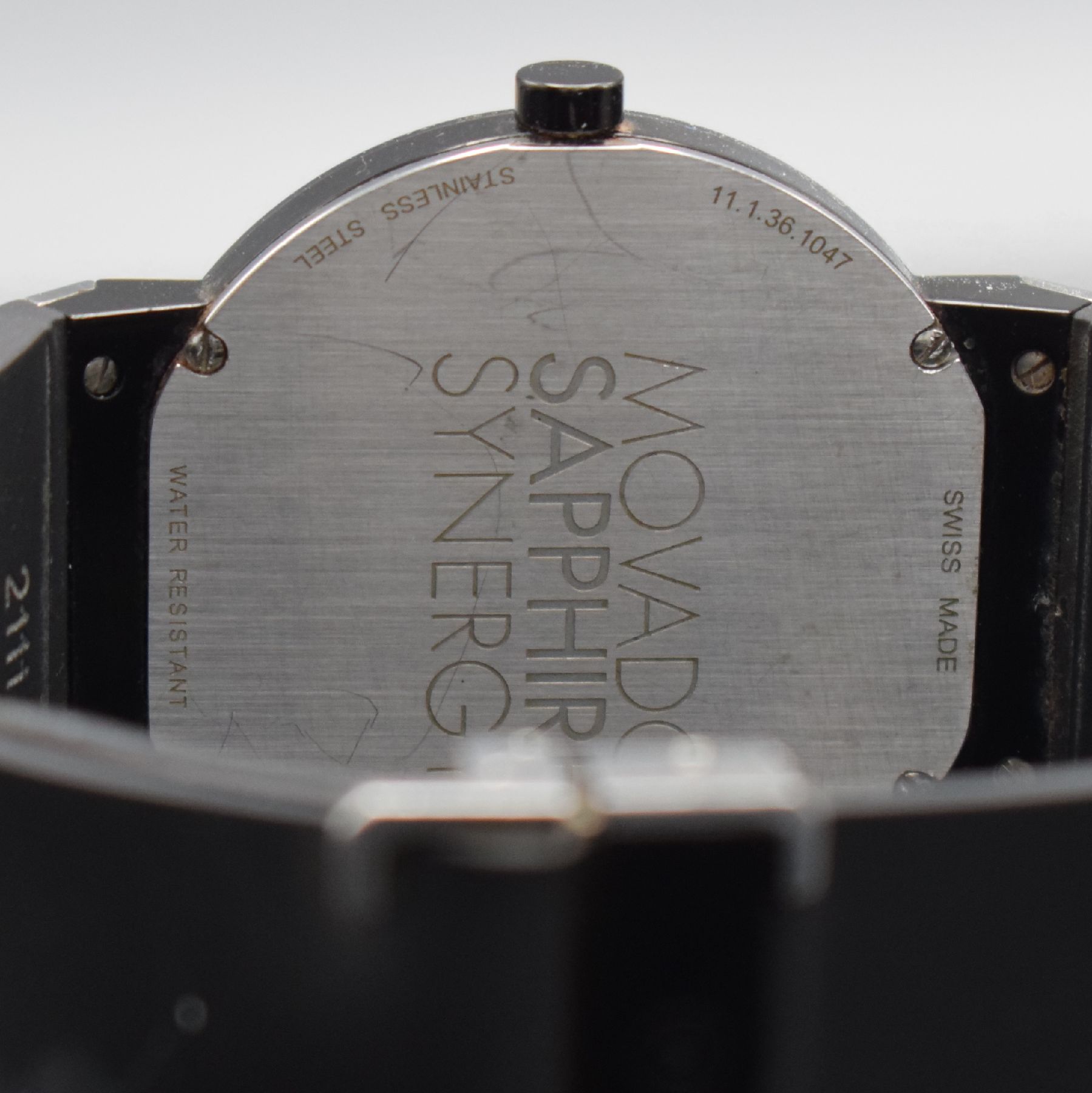 Detail e: MOVADO Herrenarmbanduhr Sapphire Synergy in Stahl, Schweiz um 2010, quarz, z. T. schwarz PVD besch. Edelstahlgeh., Boden 4-fach verschr., orig. ...