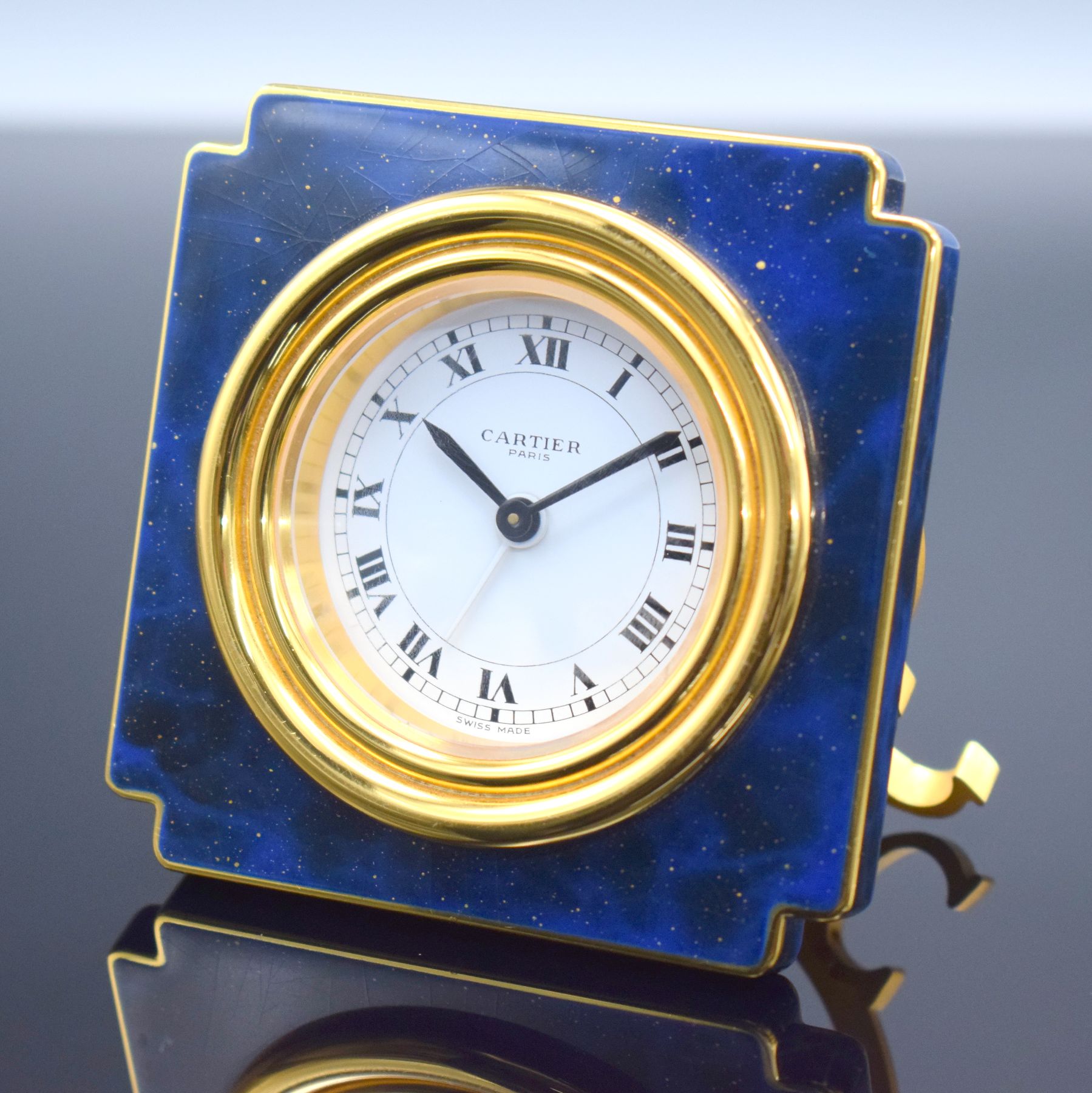 CARTIER Paris Tischwecker Referenz 7512, Schweiz um 1970, Handaufzug, verg. Metallgeh. teils lackiert, Lackierung riss., emailfarb. Zifferbl. m. ...