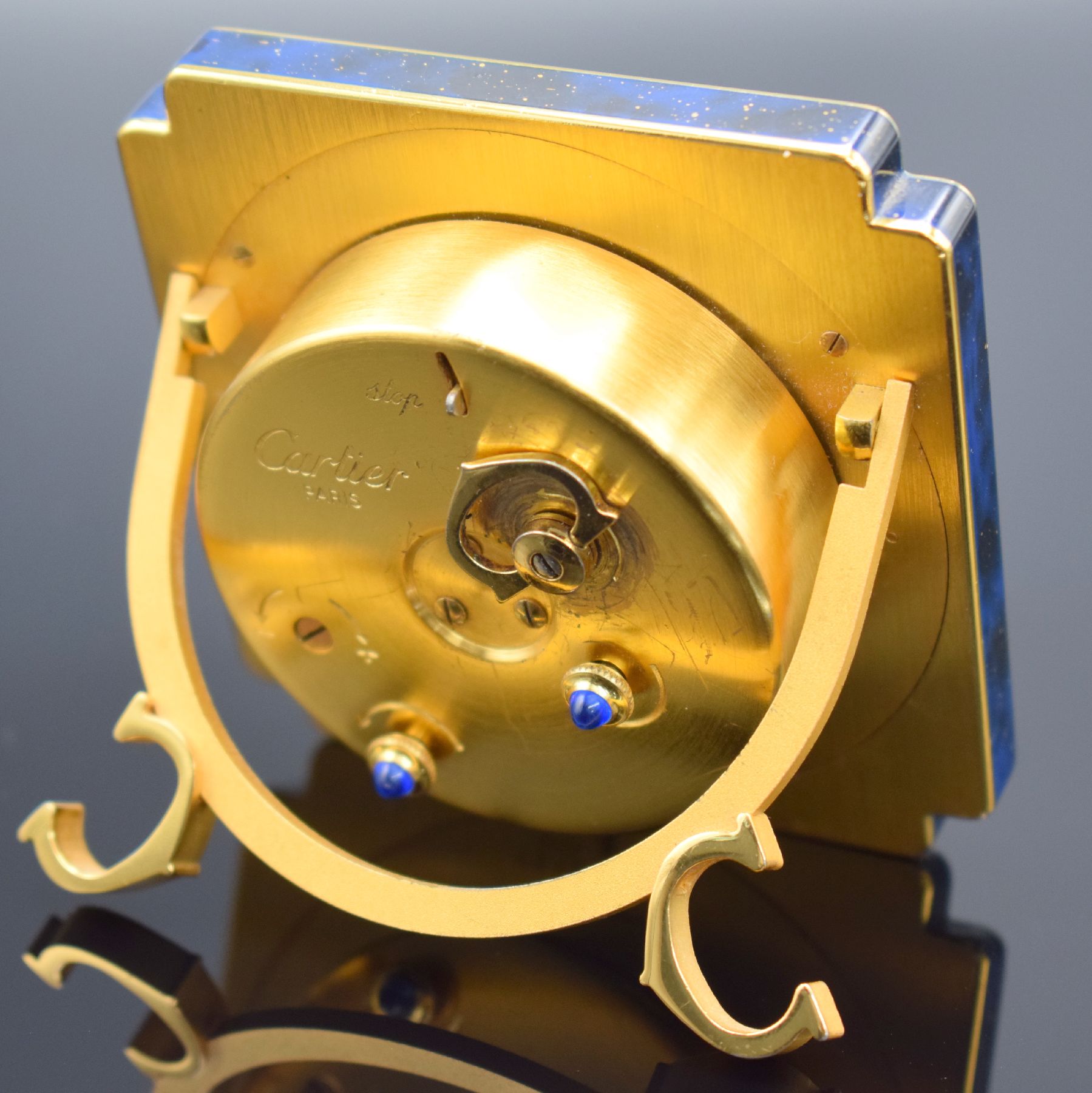 Detail d: CARTIER Paris Tischwecker Referenz 7512, Schweiz um 1970, Handaufzug, verg. Metallgeh. teils lackiert, Lackierung riss., emailfarb. Zifferbl. m. ...