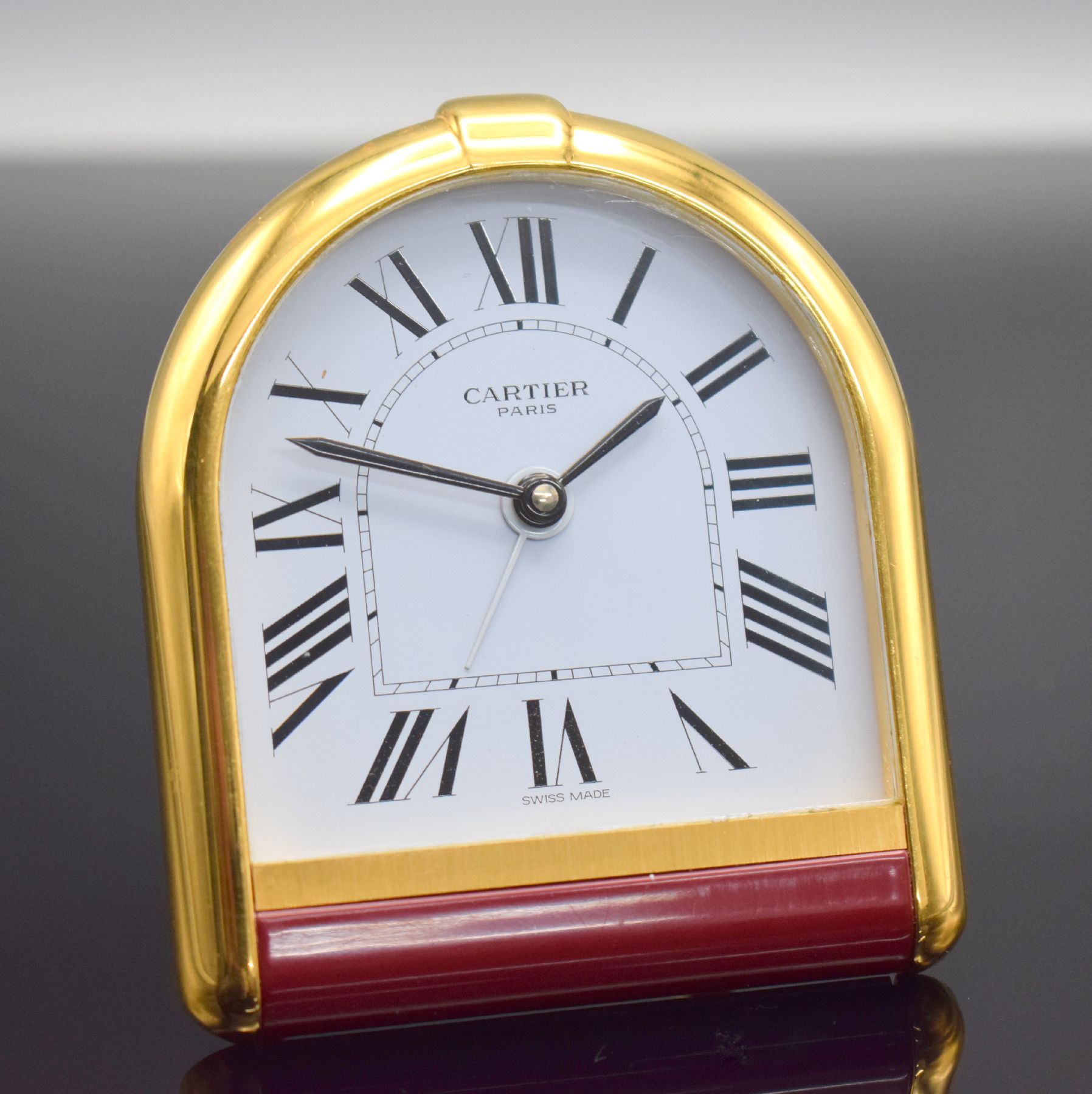 CARTIER Paris Tischwecker, Schweiz 1980er Jahre, quarz, verg. Messinggeh. teils lackiert, emailfarb. Zifferbl. m. röm. Zahlen, M. ca. 87 x 76 mm, ...