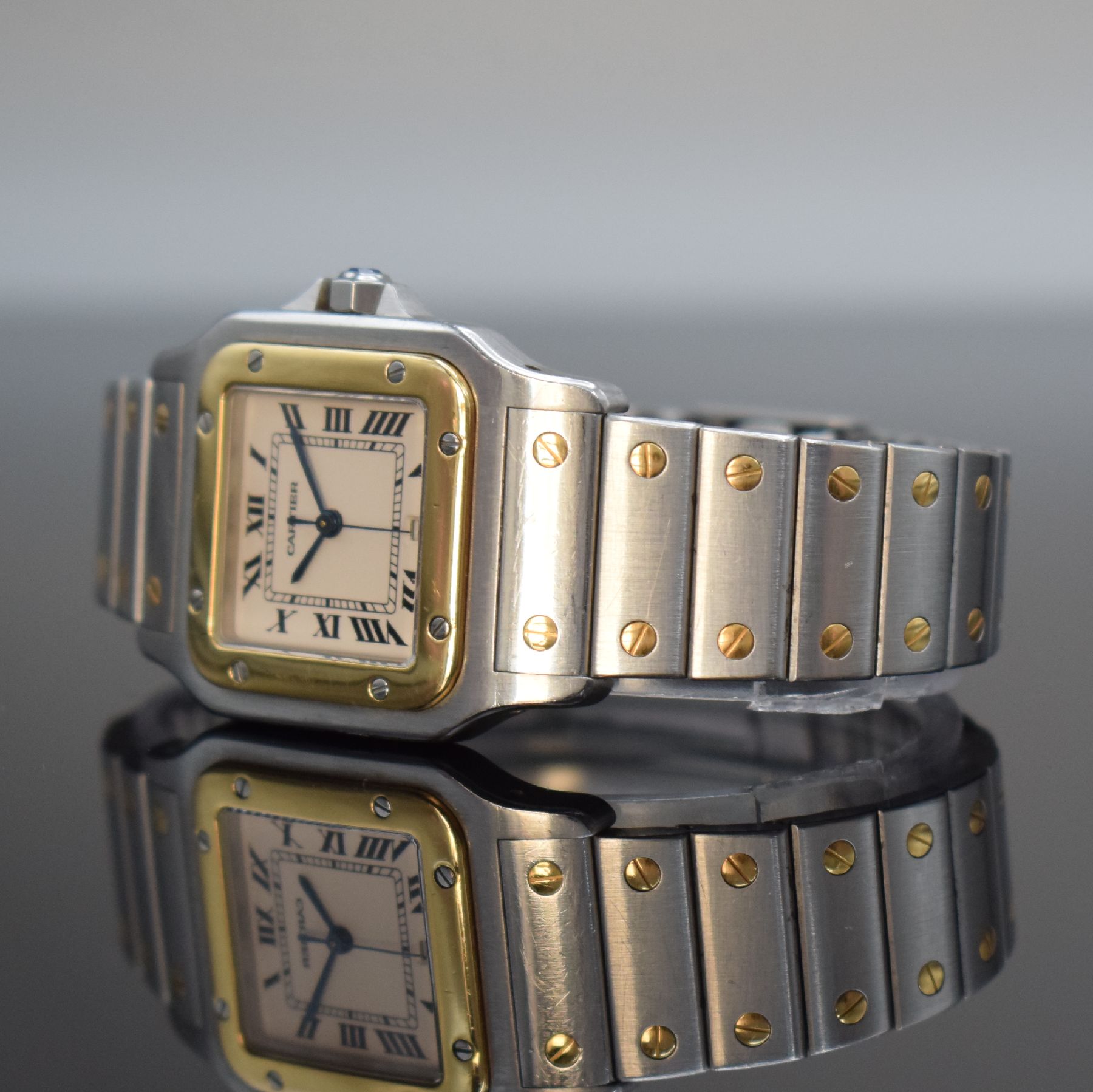 Detail d: CARTIER Santos Herrenarmbanduhr, Schweiz um 1991, quarz, Edelstahl & Gold komb. inkl. Gliederband m. Faltschl., Goldlünette, Boden 8-fach verschr., ...