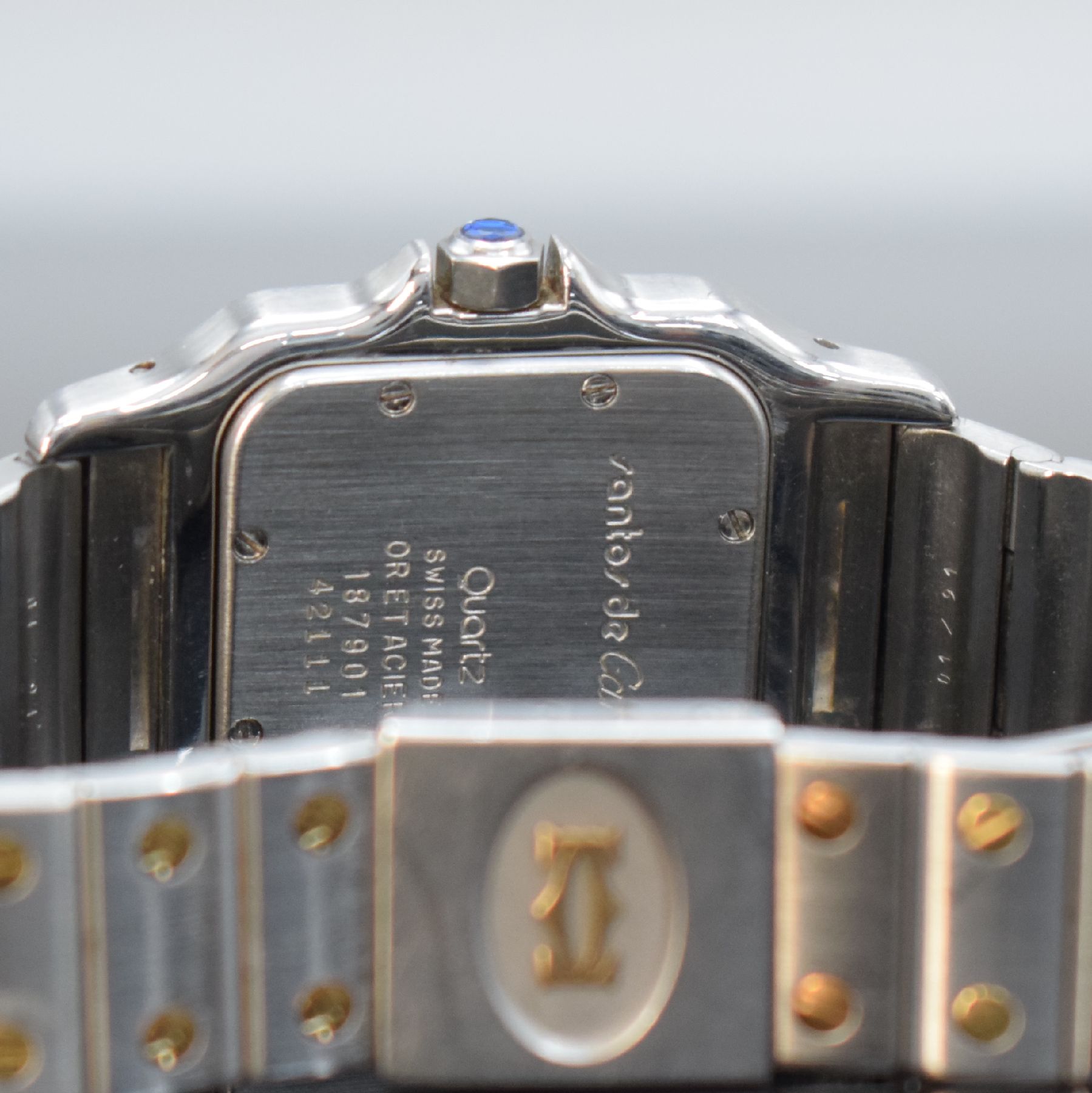 Detail e: CARTIER Santos Herrenarmbanduhr, Schweiz um 1991, quarz, Edelstahl & Gold komb. inkl. Gliederband m. Faltschl., Goldlünette, Boden 8-fach verschr., ...