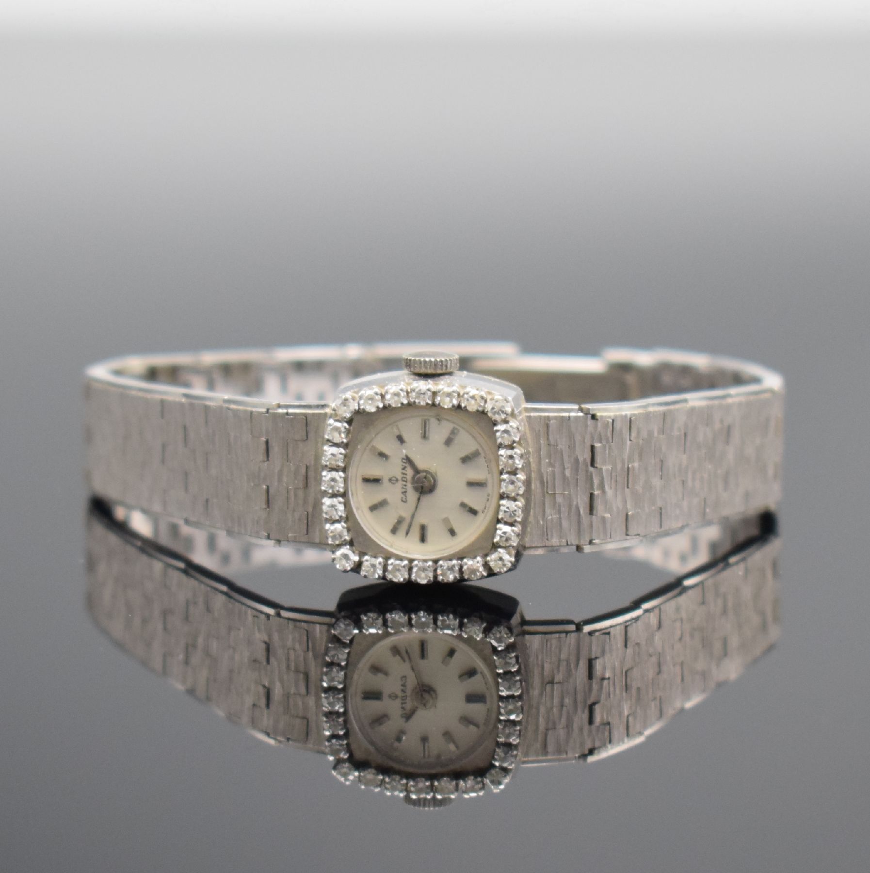 CANDINO Damenarmbanduhr mit Diamantbesatz in WG 750/000, Schweiz um 1970, Handaufzug, Boden aufgedr., Geh. an Goldband 750/000, silb. Zifferbl. m. ...