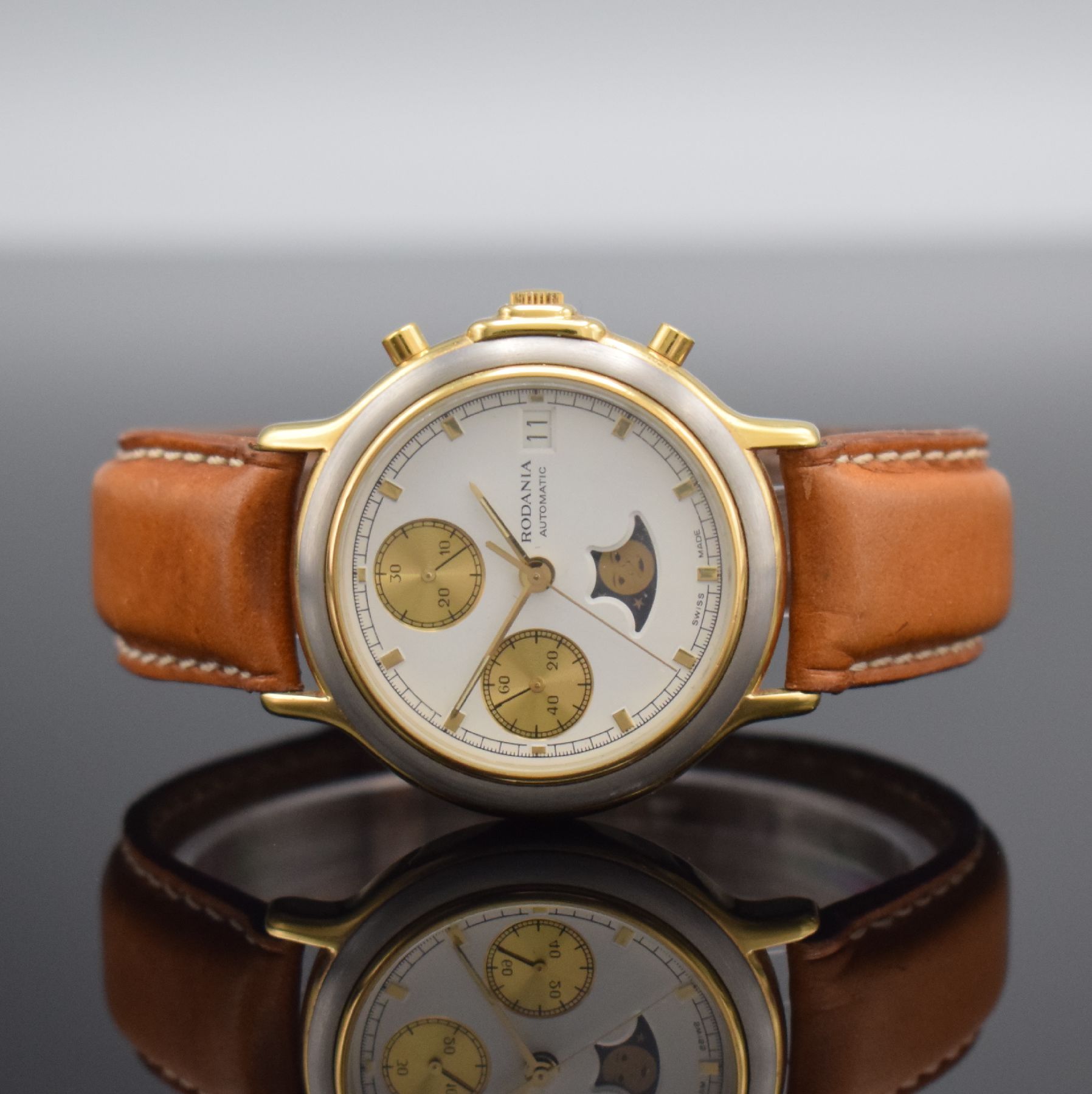 RODANIA Herrenarmbanduhr mit Chronograph & Mondphase, Schweiz um 1985, Automatik, verg. Geh., Boden aufgedr., weißes Zifferbl. m. gold. Ind. & ...