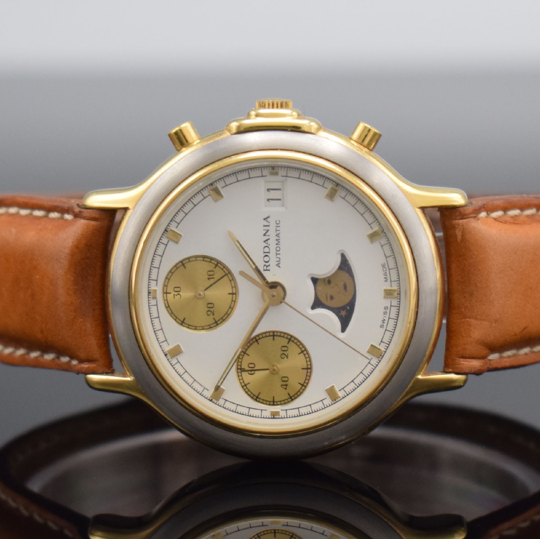 Detail a: RODANIA Herrenarmbanduhr mit Chronograph & Mondphase, Schweiz um 1985, Automatik, verg. Geh., Boden aufgedr., weißes Zifferbl. m. gold. Ind. & ...