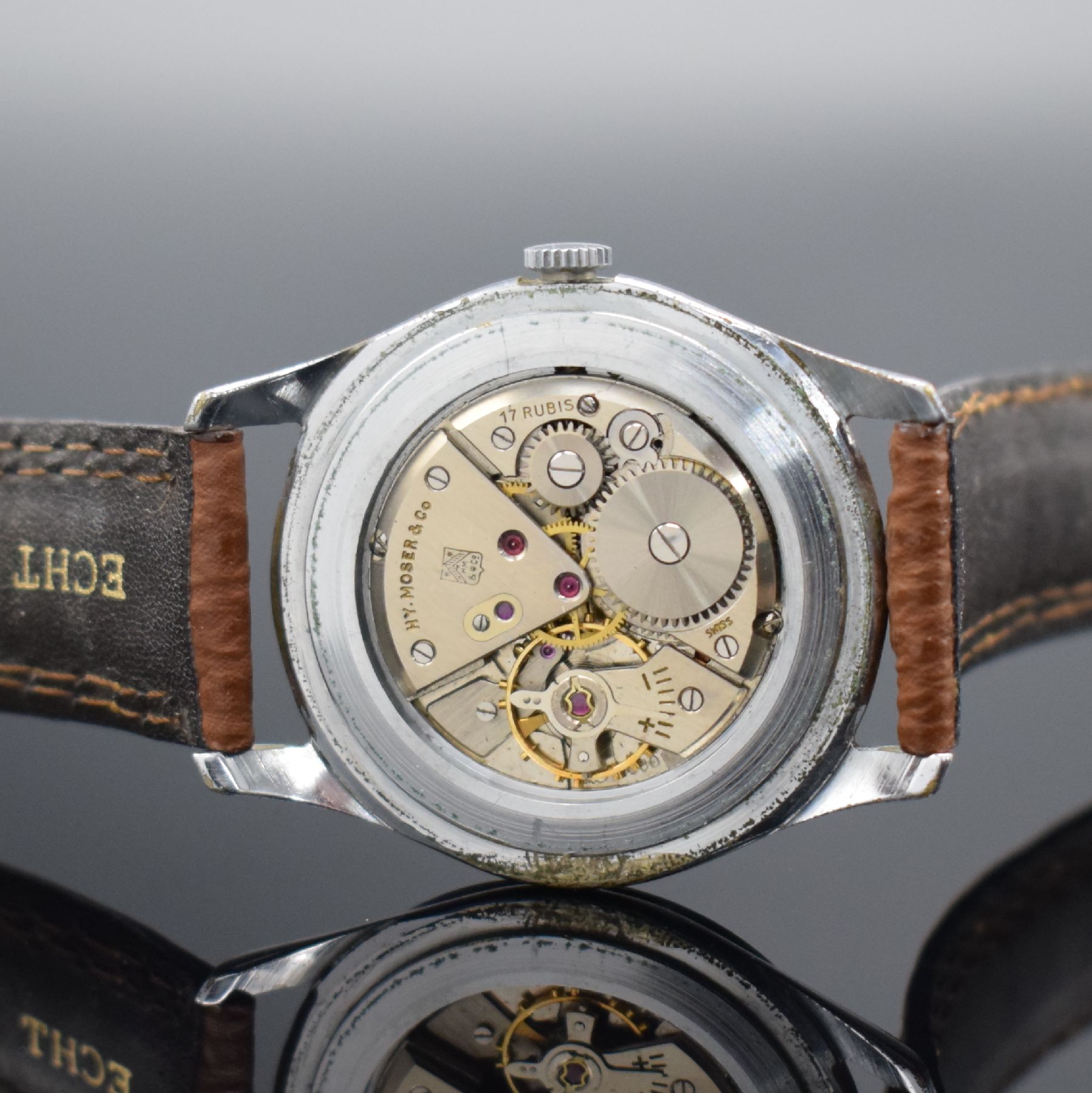 Detail e: HENRY MOSER & Cie Herrenarmbanduhr, Schweiz um 1950, 3-tlg. verchromtes Geh., Glasrand & Boden aufgedr., schönes matt vers. Zifferbl., rotgold. ...