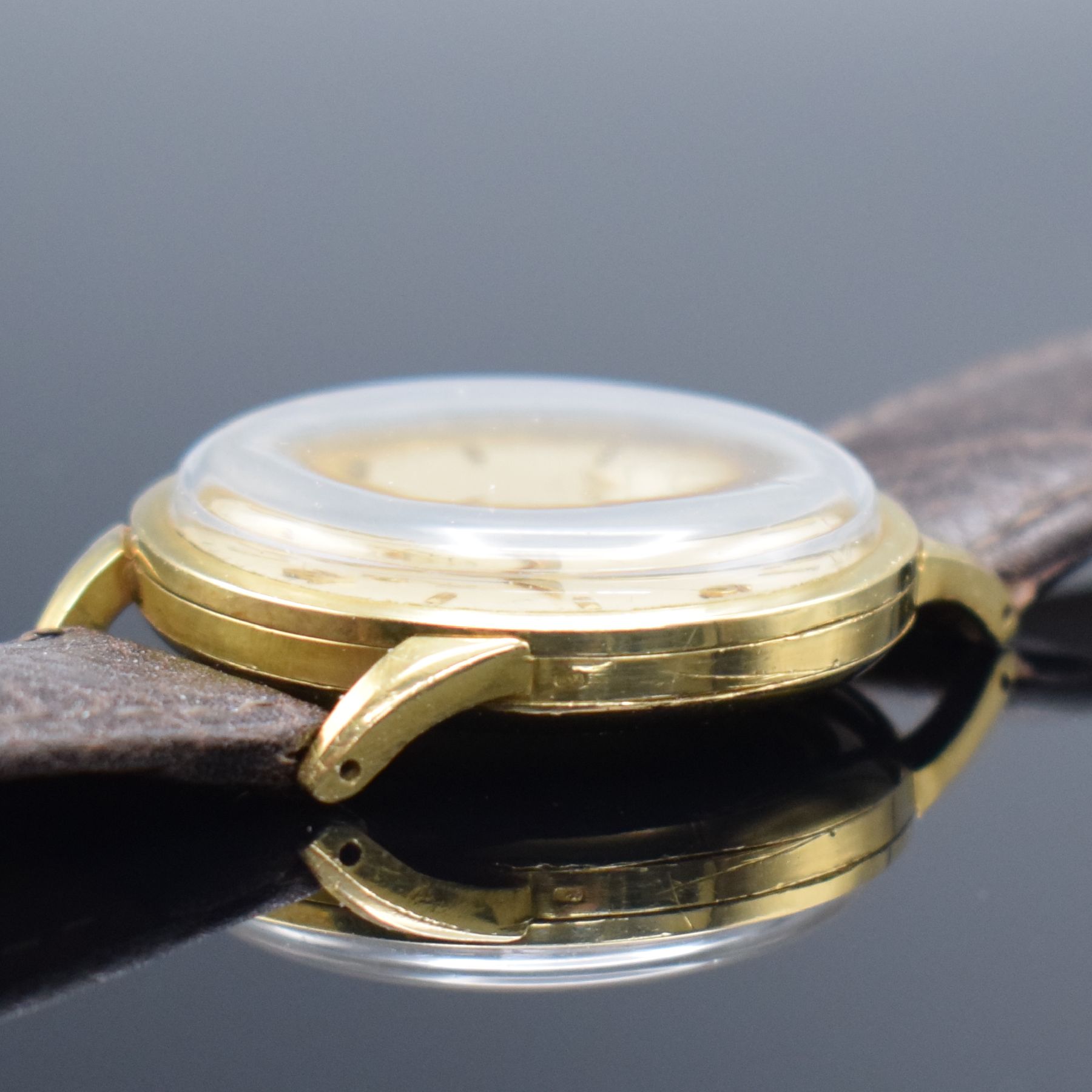 Detail e: CYMA Chronometer seltene Herrenarmbanduhr in GG 750/000, Schweiz um 1950, 3-tlg. Geh., Boden & Glasrand aufgedr., silb. Zifferbl. fl./pat., aufges. ...