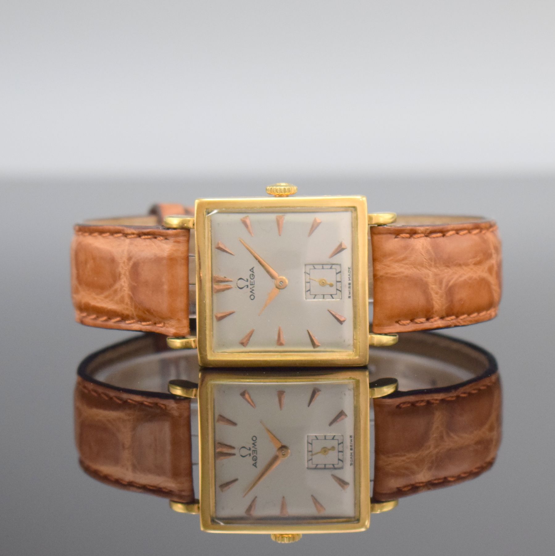 OMEGA Damenarmbanduhr in GG 750/000, Schweiz um 1945, Handaufzug, Boden aufgedr., neutr. Lederband m. orig. verg. Dornschl., silb. Zifferbl. m. gold. ...