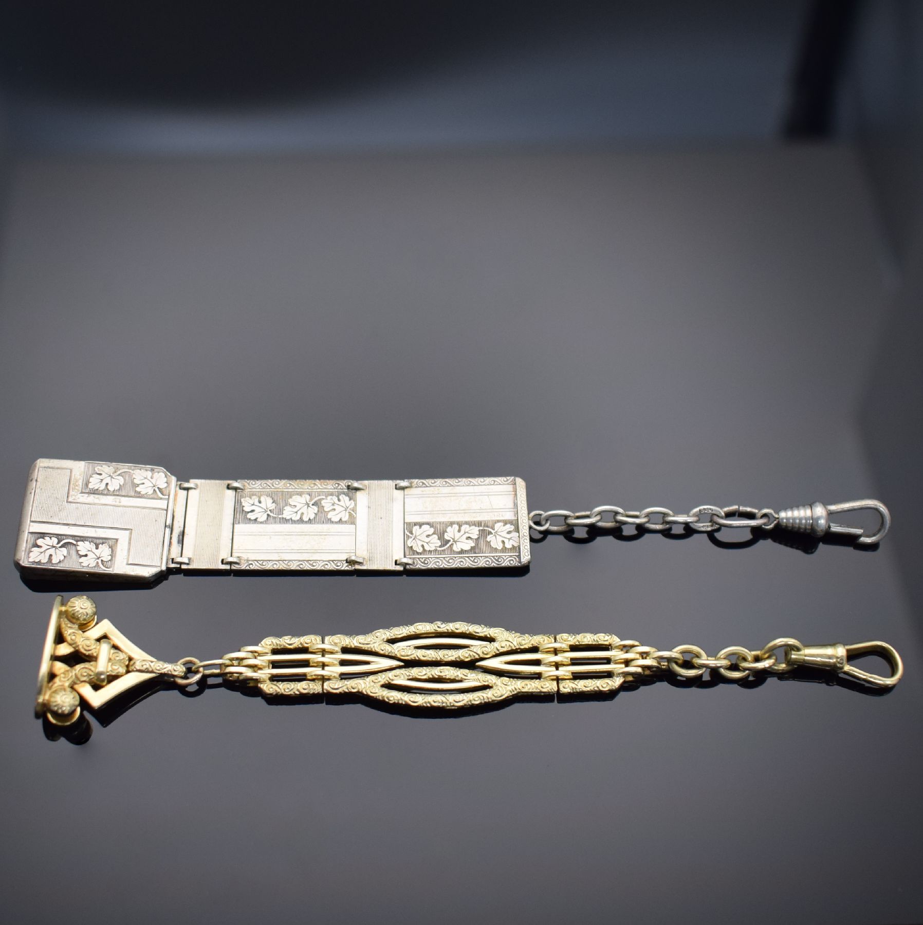 2 Taschenuhr-Chatelaines, 1x in GG 585/000 & 1x in Silber, um 1900 - 1920, 1) mit Karabiner & Anhänger m. Monogramm, aufw. graviert & dekoriert, L. ...