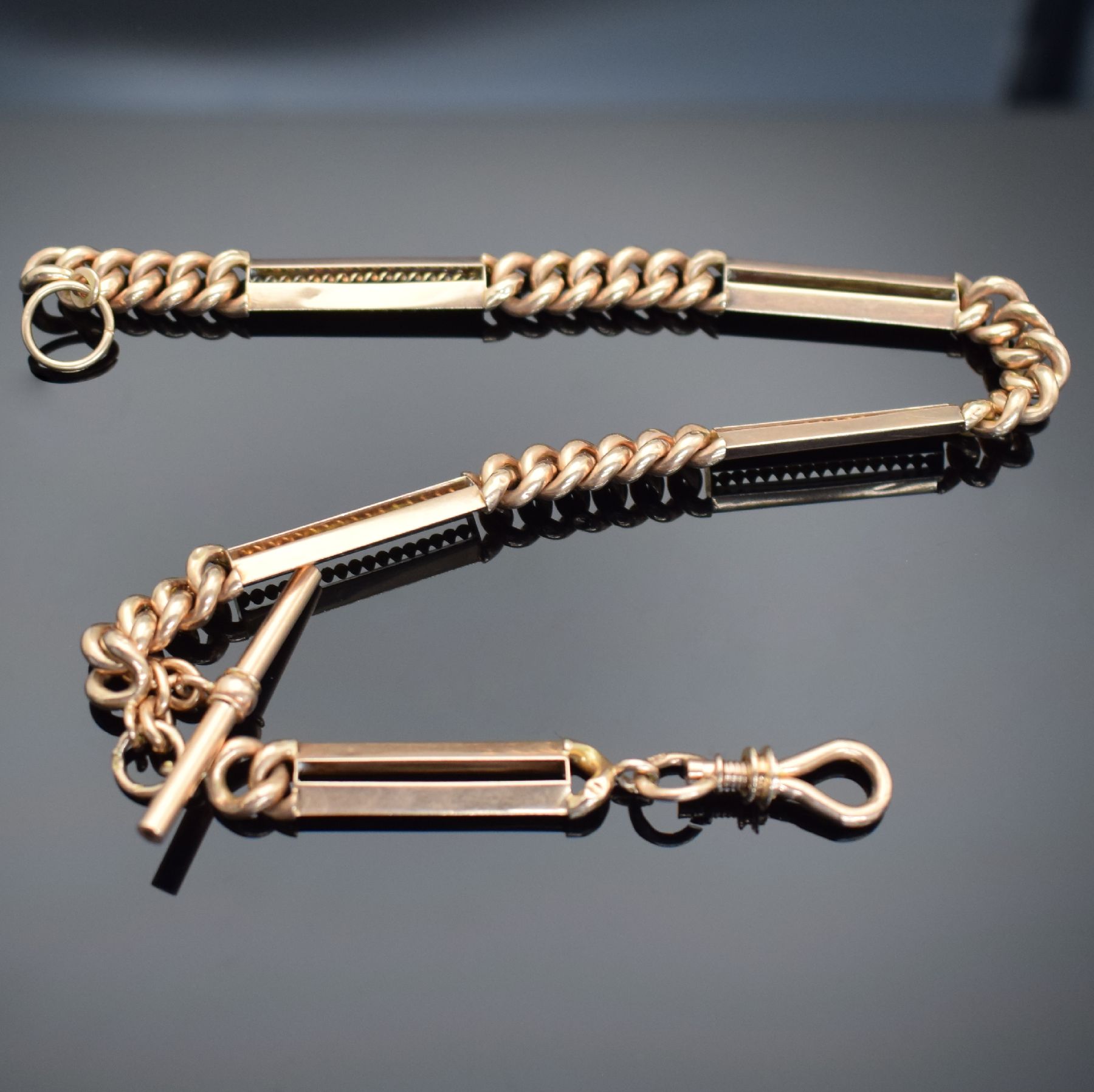 Taschenuhrkette in RG 585/000 mit Karabiner & Knebel, um 1900, ausgefallenes Design, L. ca. 32 cm, Gew. ca. 30g, dell., Zwischenteile z. T. nicht ...