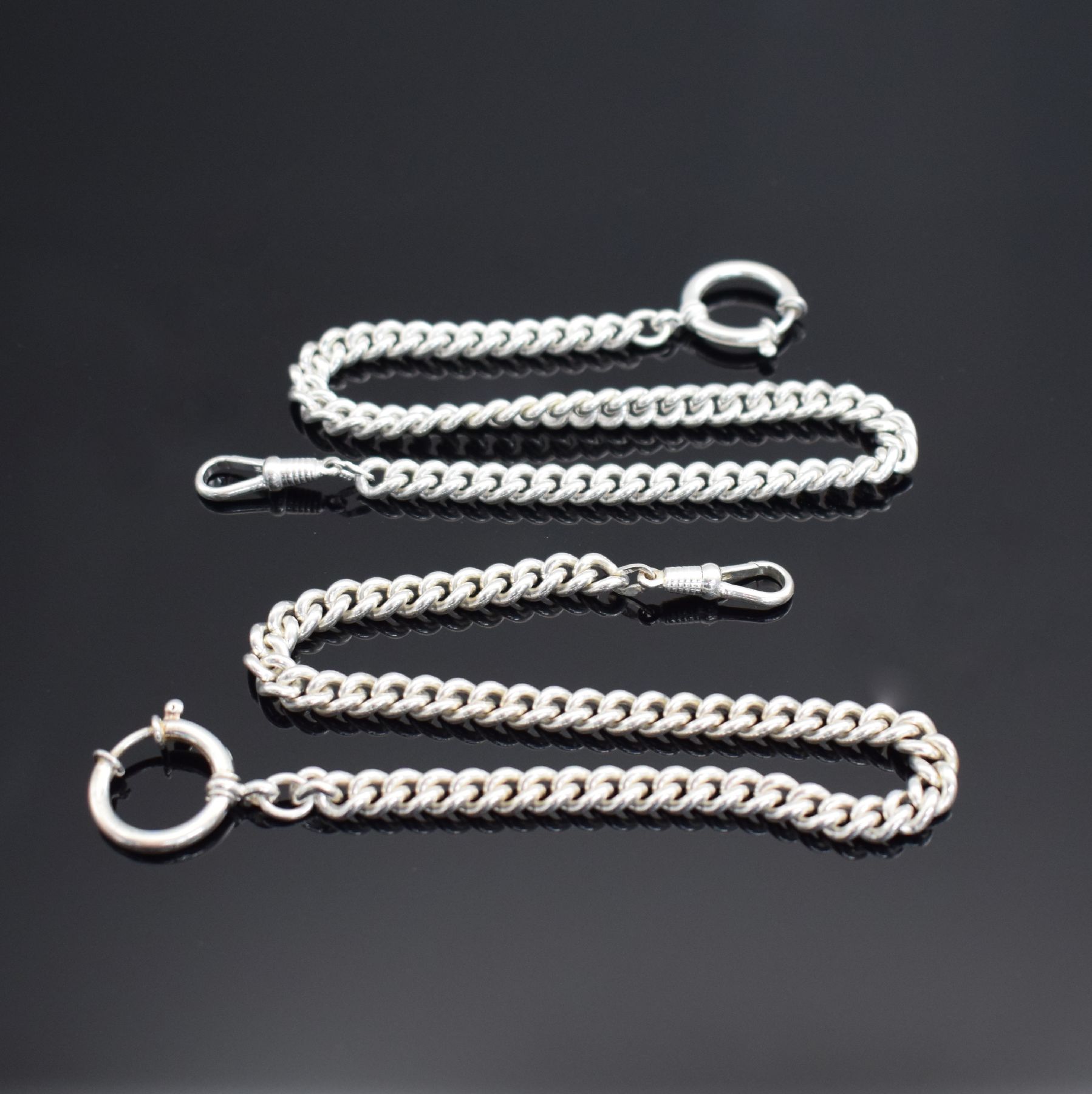 2 Taschenuhrketten in Sterlingsilber, Panzerketten ohne Verlauf, mit Federring & Karabiner, L. jeweils ca. 30 cm, Gew. ca. 78g, EZ 1-2