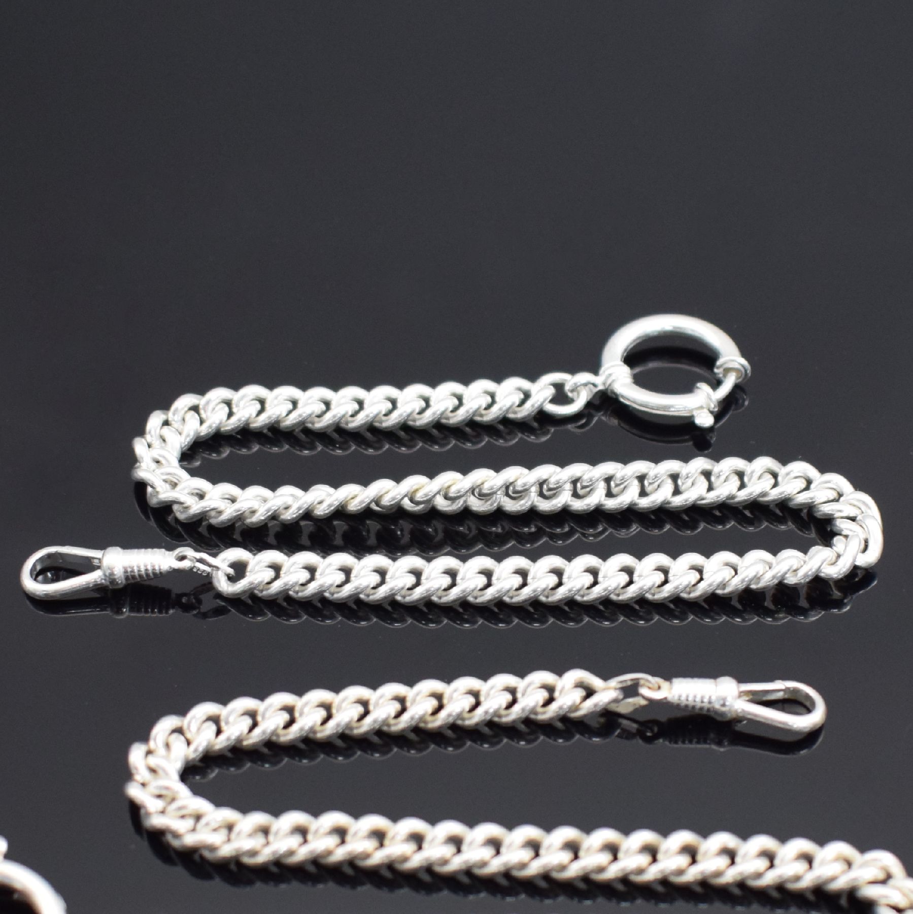Detail b: 2 Taschenuhrketten in Sterlingsilber, Panzerketten ohne Verlauf, mit Federring & Karabiner, L. jeweils ca. 30 cm, Gew. ca. 78g, EZ 1-2