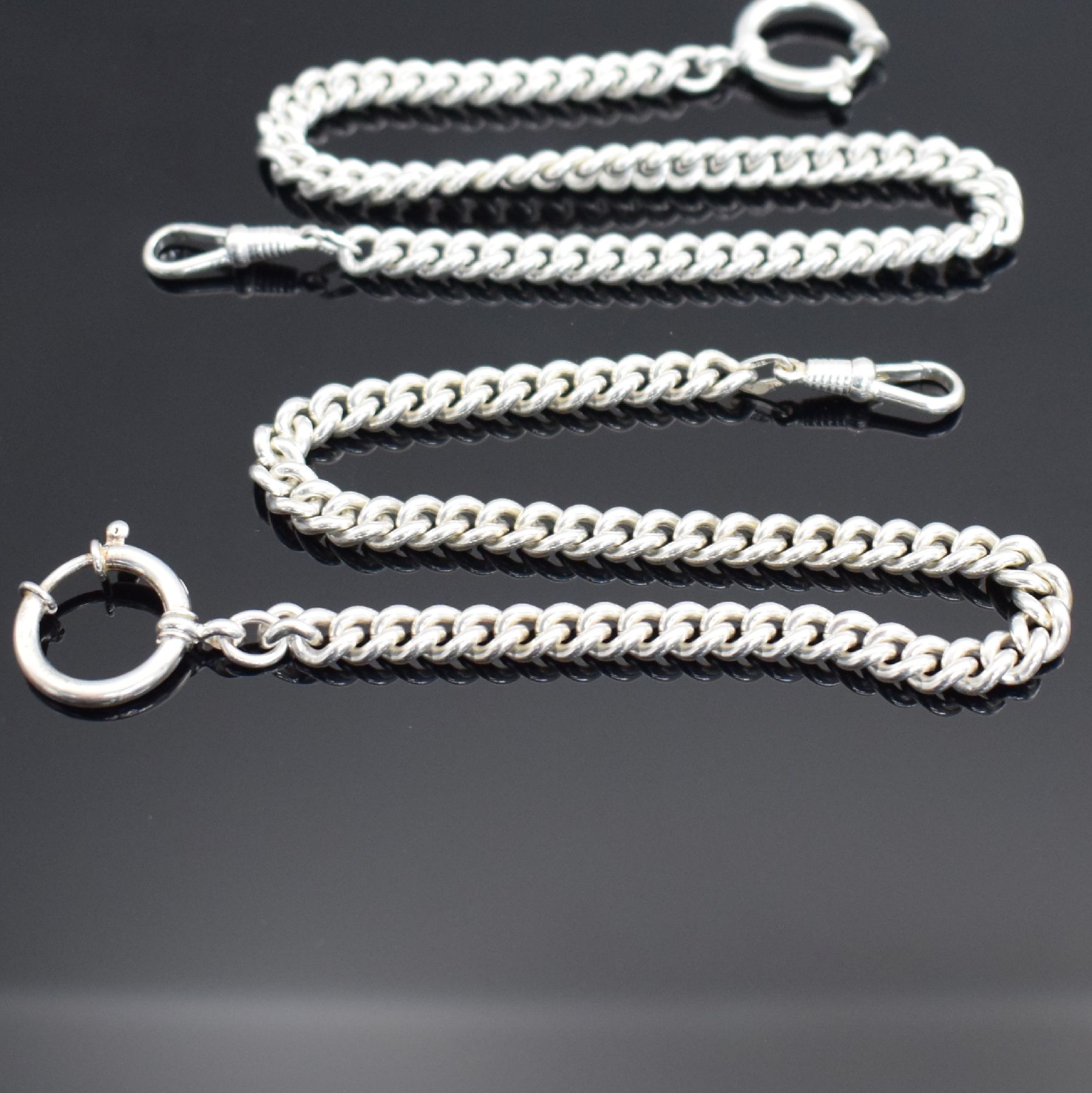 Detail c: 2 Taschenuhrketten in Sterlingsilber, Panzerketten ohne Verlauf, mit Federring & Karabiner, L. jeweils ca. 30 cm, Gew. ca. 78g, EZ 1-2