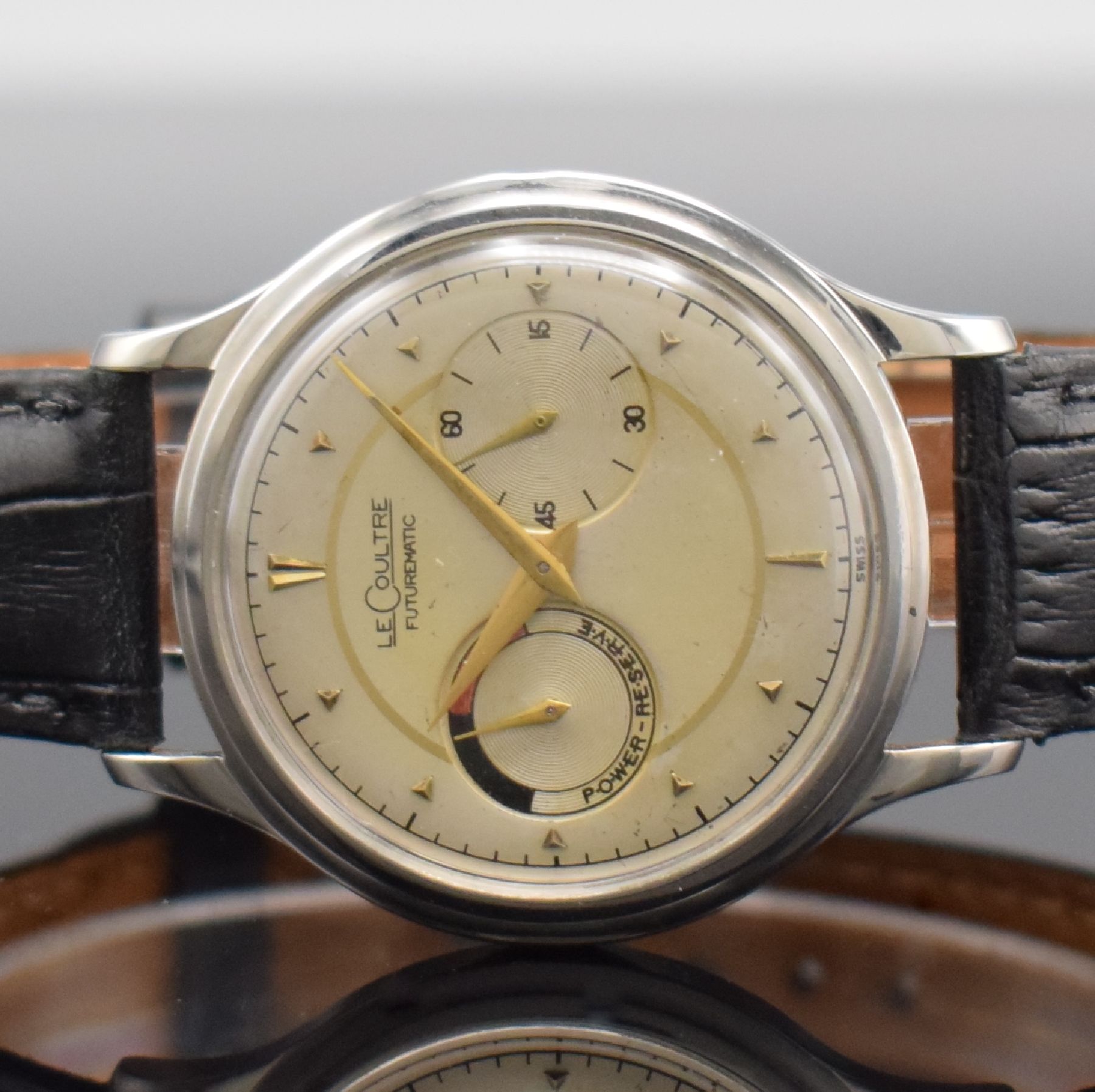 Detail a: LeCoultre Futurematic Herrenarmbanduhr in Stahl mit Gangreserve, Schweiz um 1955, Hammerautomatik, 2-teil. Geh., Boden verschr., silb. pat. Zifferbl. ...