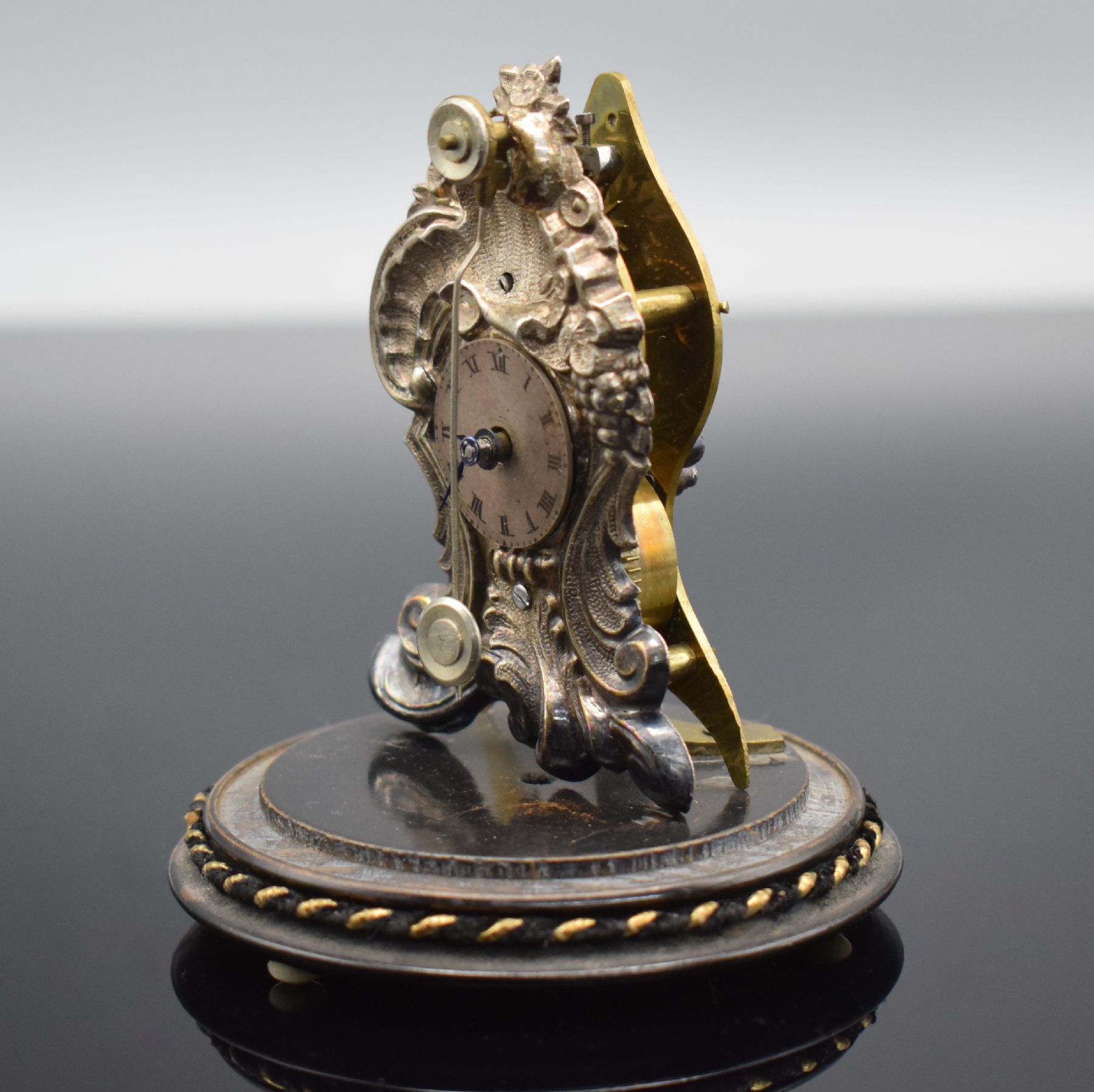 Detail d: Miniatur Vorderzappler unter Glasdom, Österreich um 1870, gedrechselter Holzsockel auf drei Füßen, vers. geprägte Front in Vasenform, ...